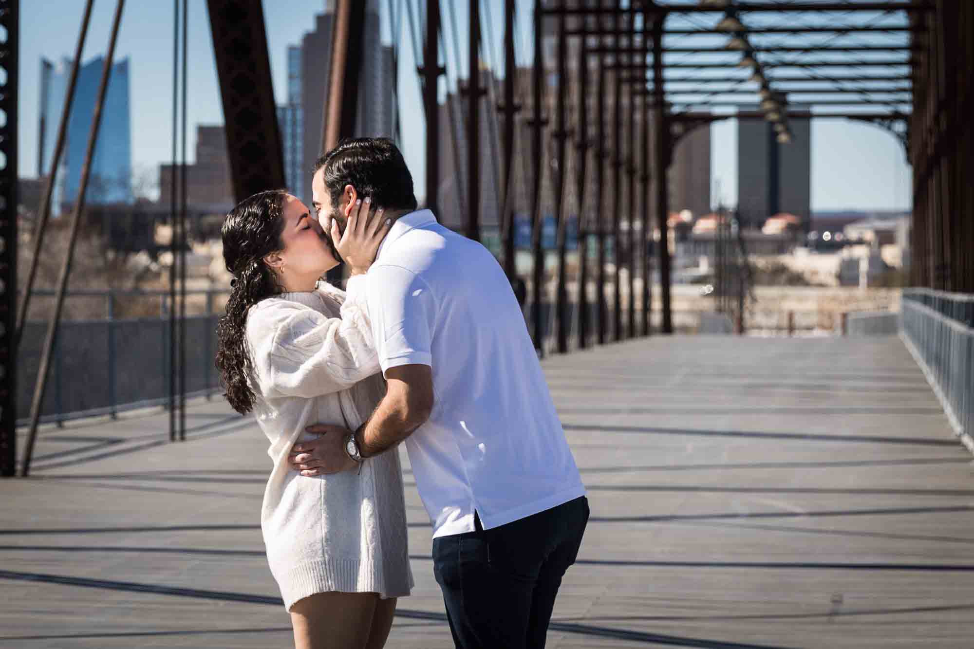 Woman kissing man and holding his face during a Hays Street Bridge proposal