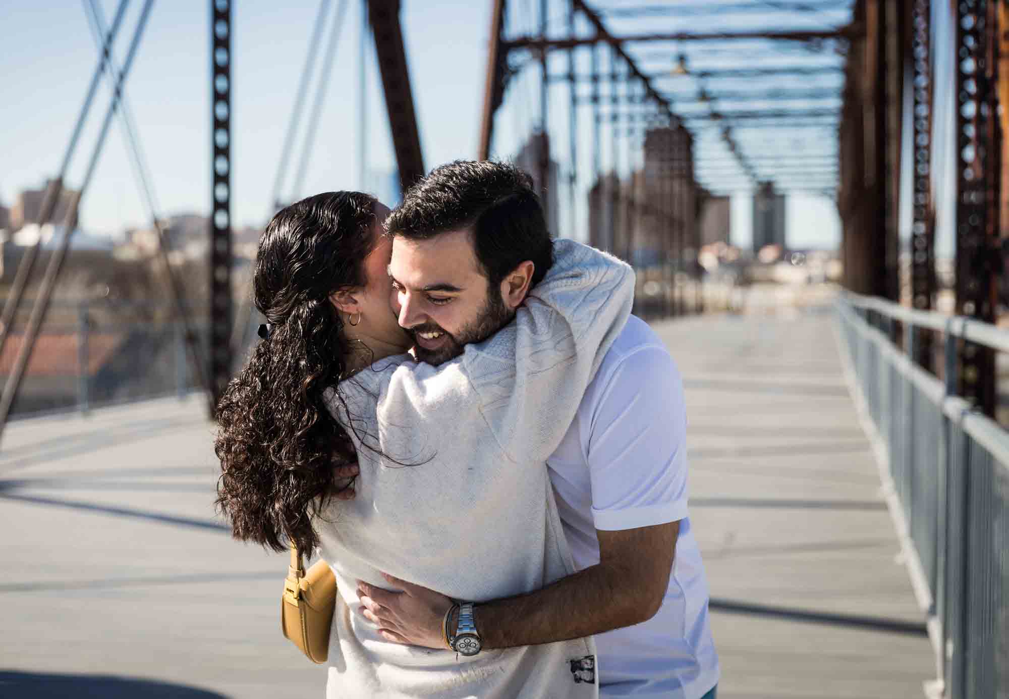 Man hugging woman on bridge during a Hays Street Bridge proposal