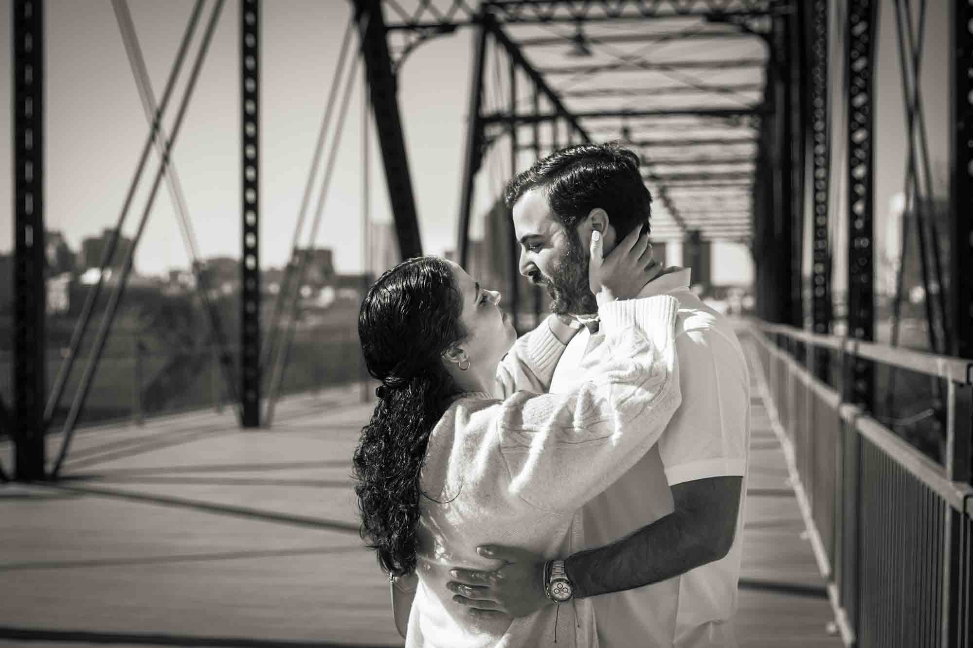Black and white photo of woman grabbing man's face during a Hays Street Bridge proposal