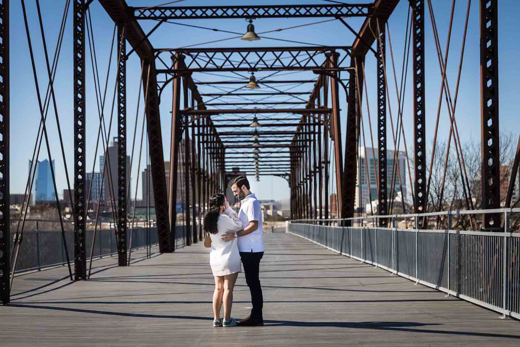 Couple hugging in middle of bridge for a Hays Street Bridge proposal