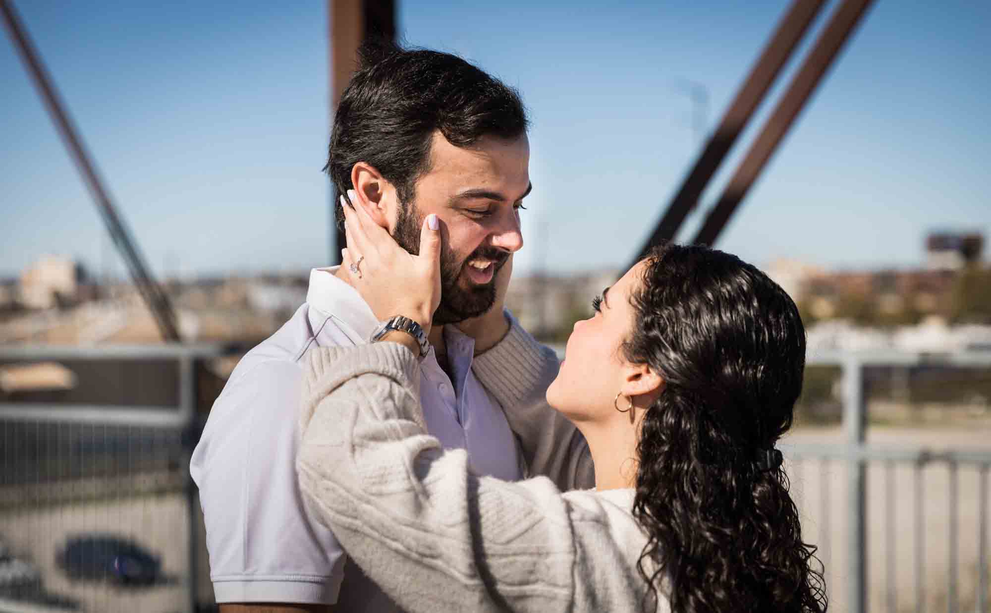 Woman holding grabbing man's cheeks on bridge during a Hays Street Bridge proposal