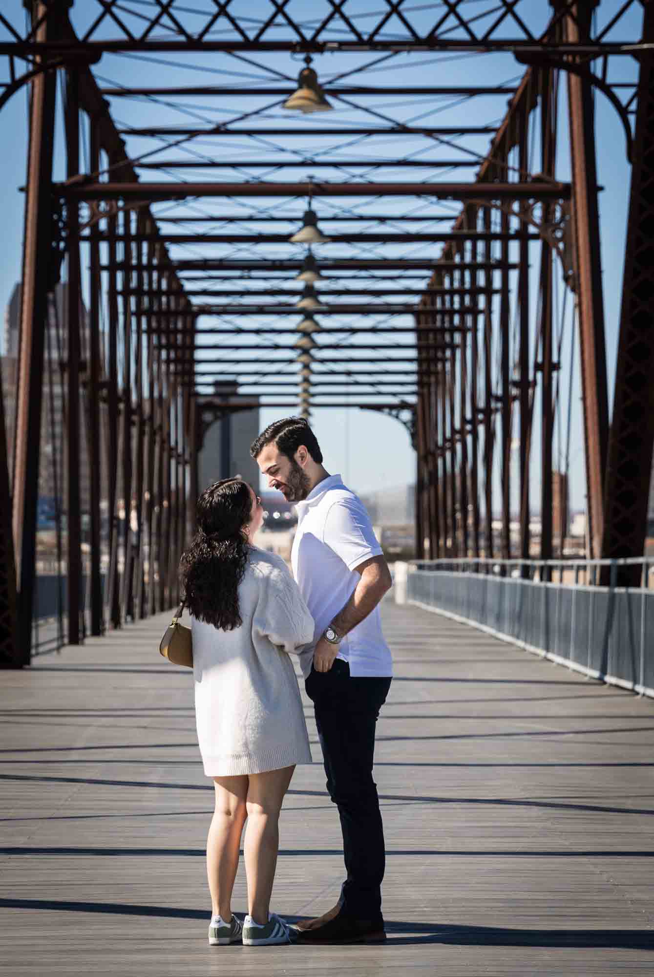 Man pulling box out of pocket in front of woman for a Hays Street Bridge proposal