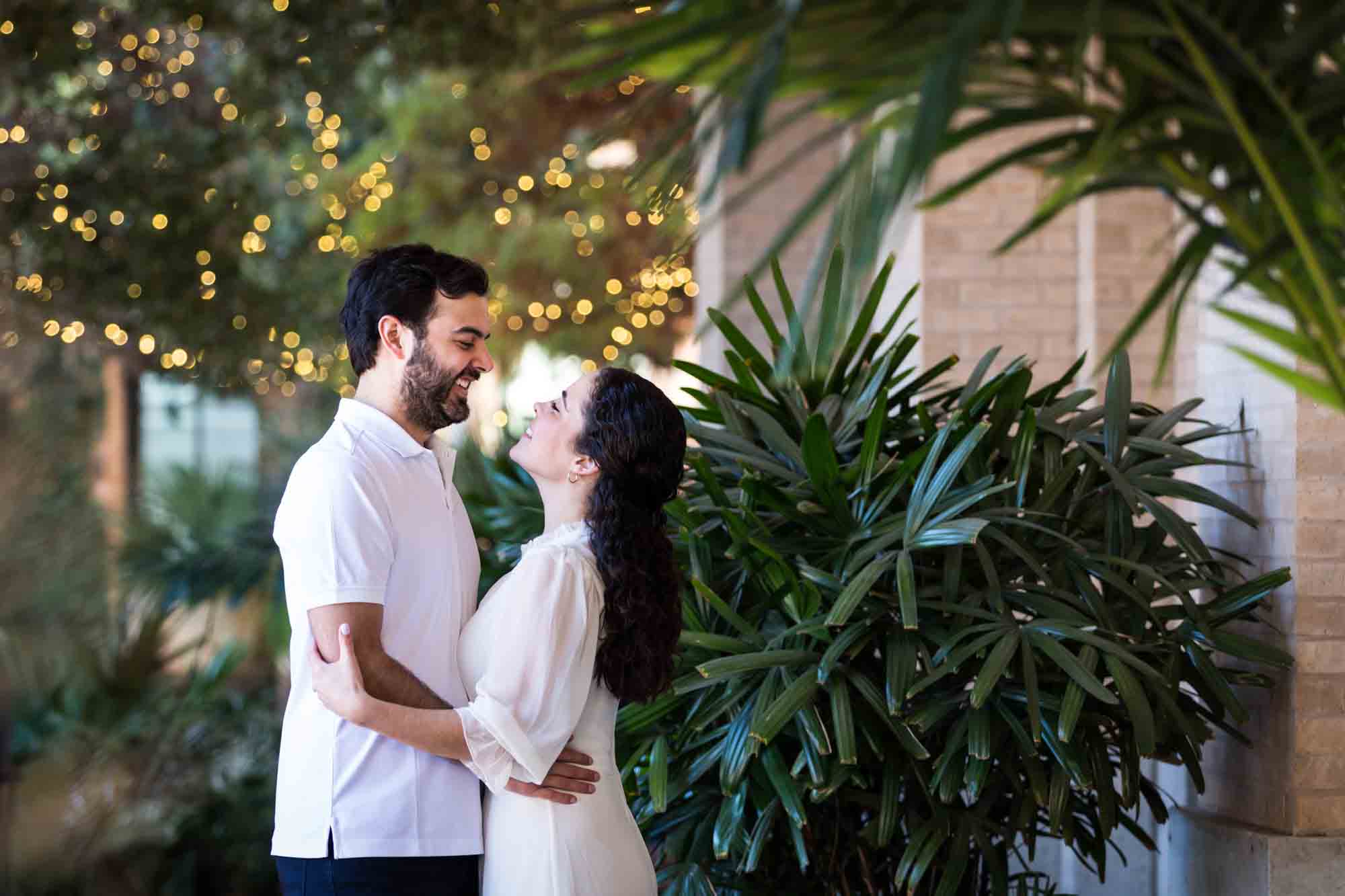 Couple dancing in front of palm trees during a Pearl engagement portrait session