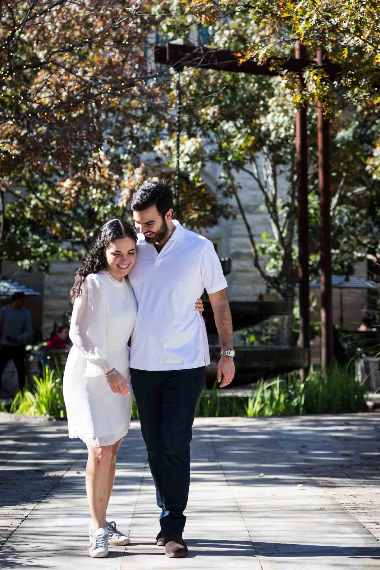 Couple walking on pathway with man's arm around woman during a Pearl engagement portrait session