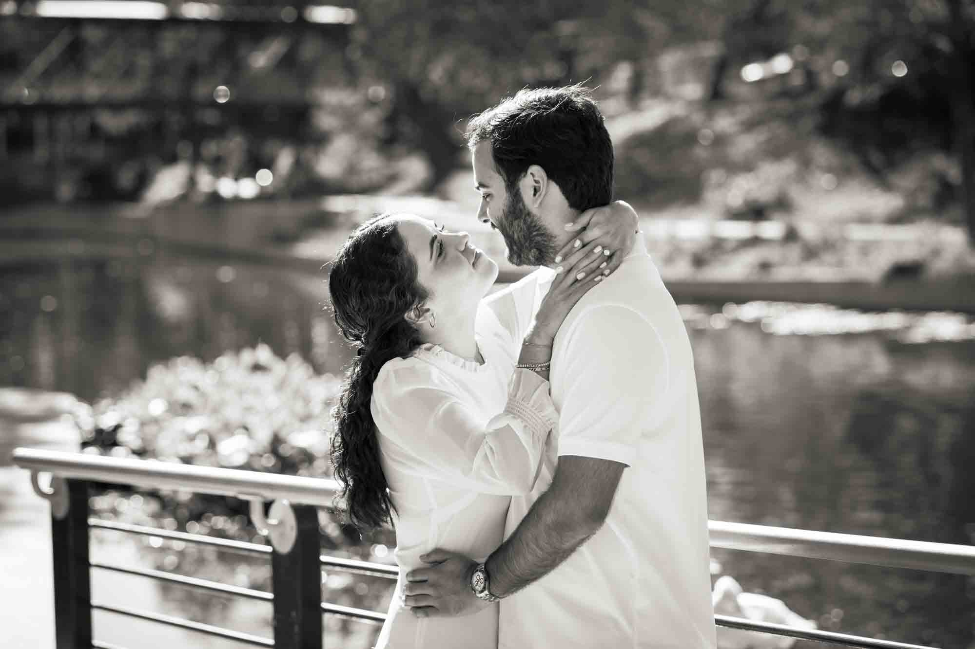 Black and white photo of couple hugging in front of Riverwalk during a Pearl engagement portrait session
