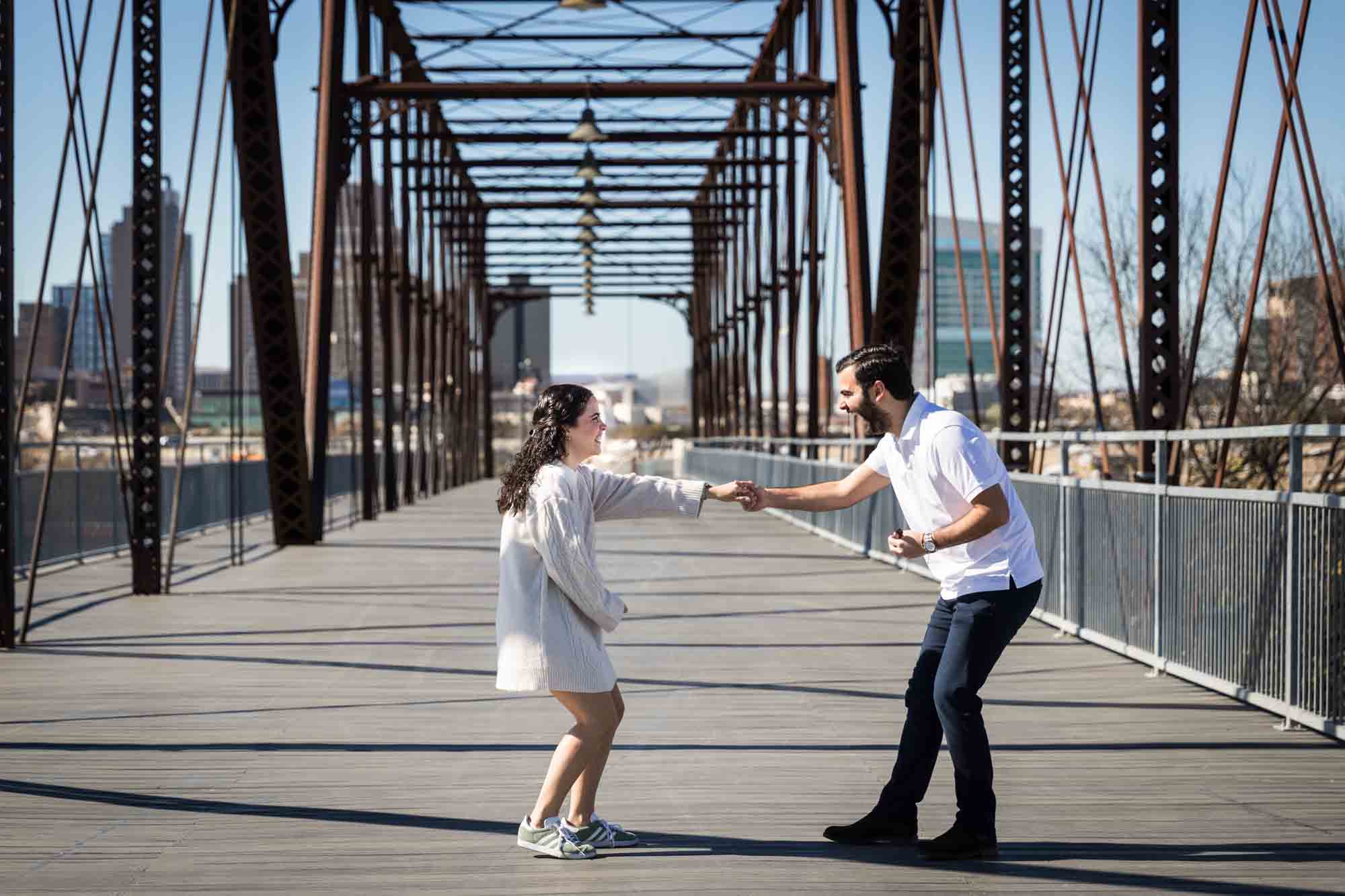 Couple holding hands and rejoicing on bridge during a Hays Street Bridge proposal