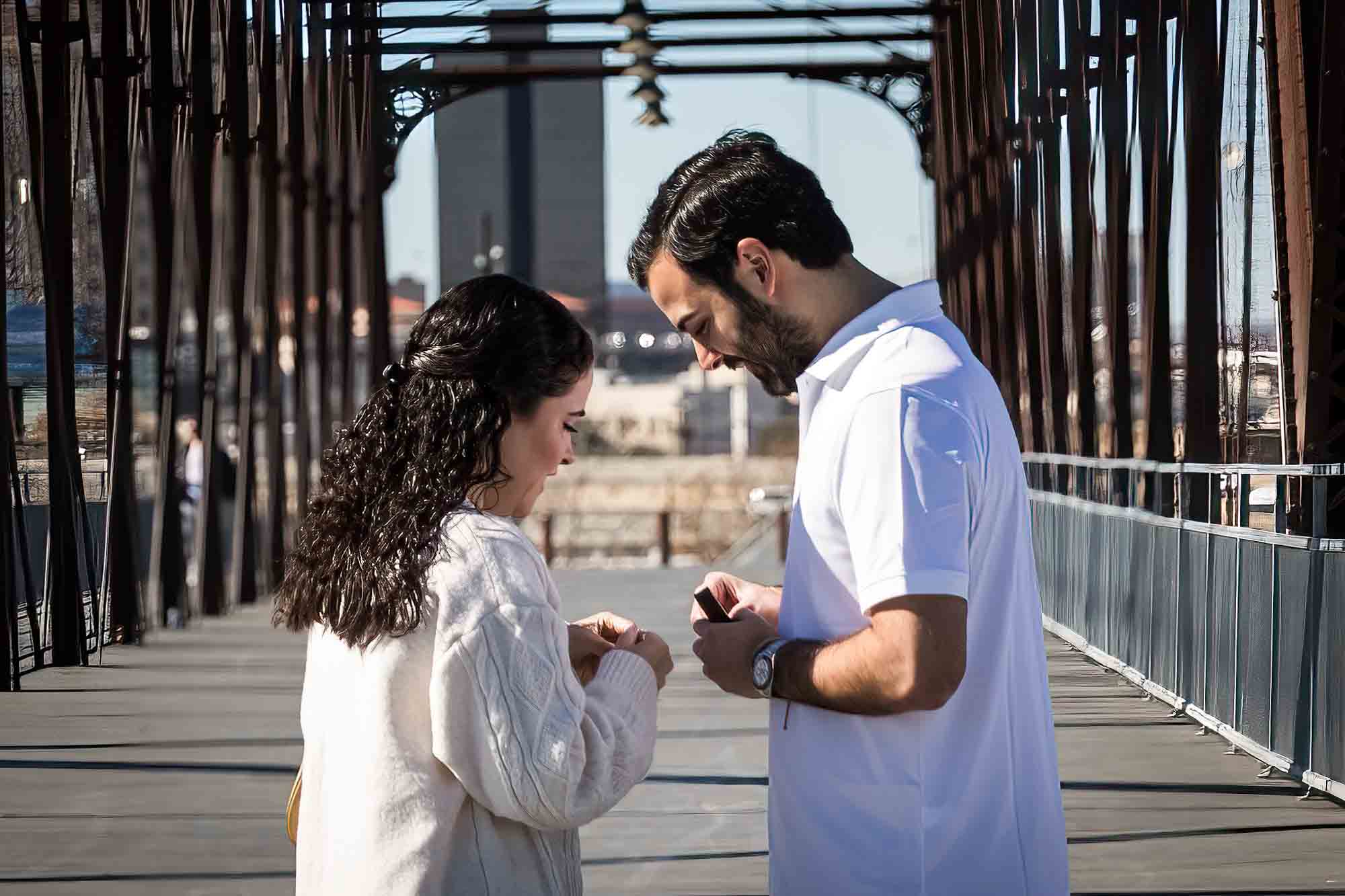 Man looking down at woman's hand during a Hays Street Bridge proposal