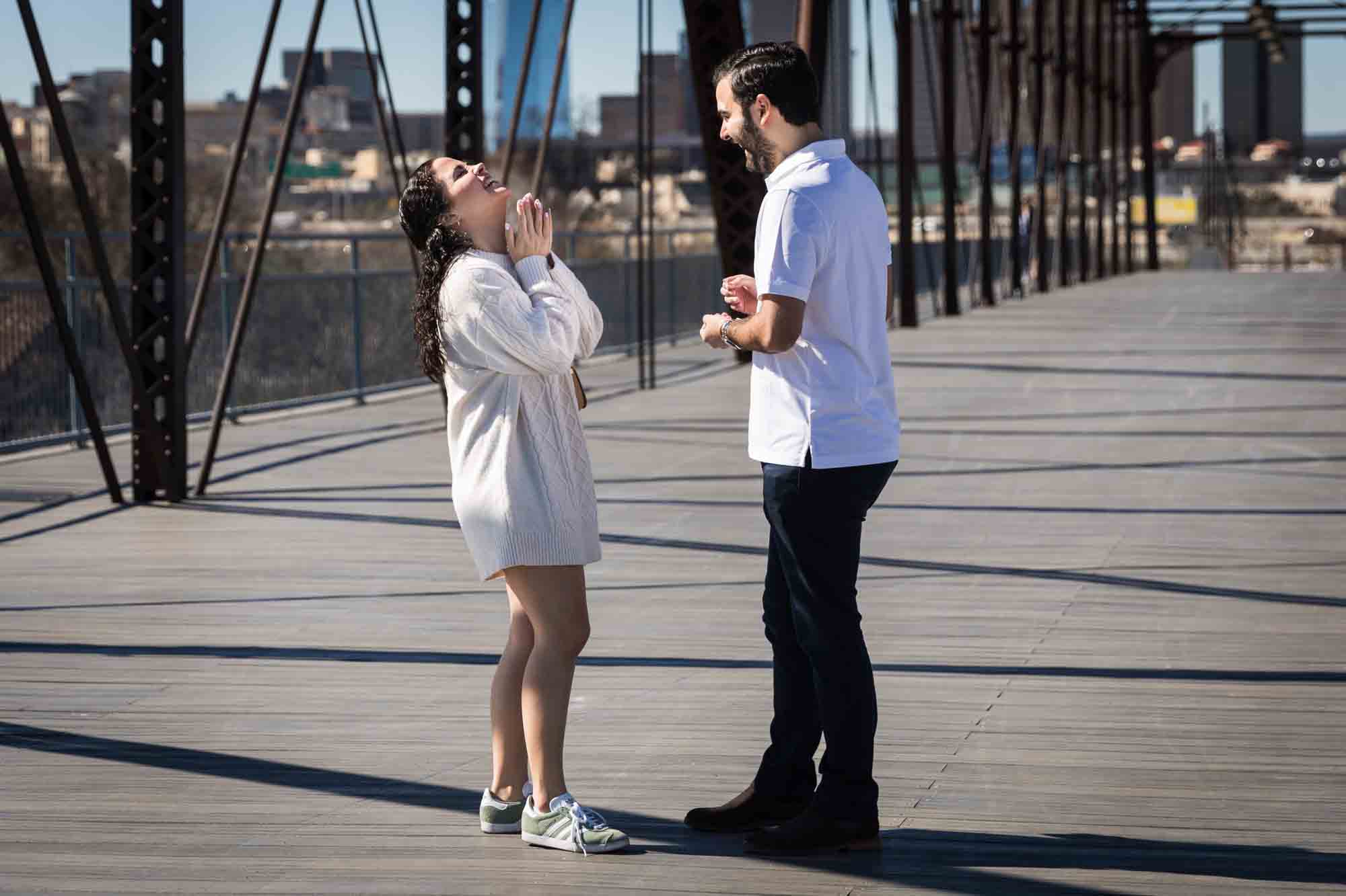 Woman looking up at the sky in front of a man during a Hays Street Bridge proposal