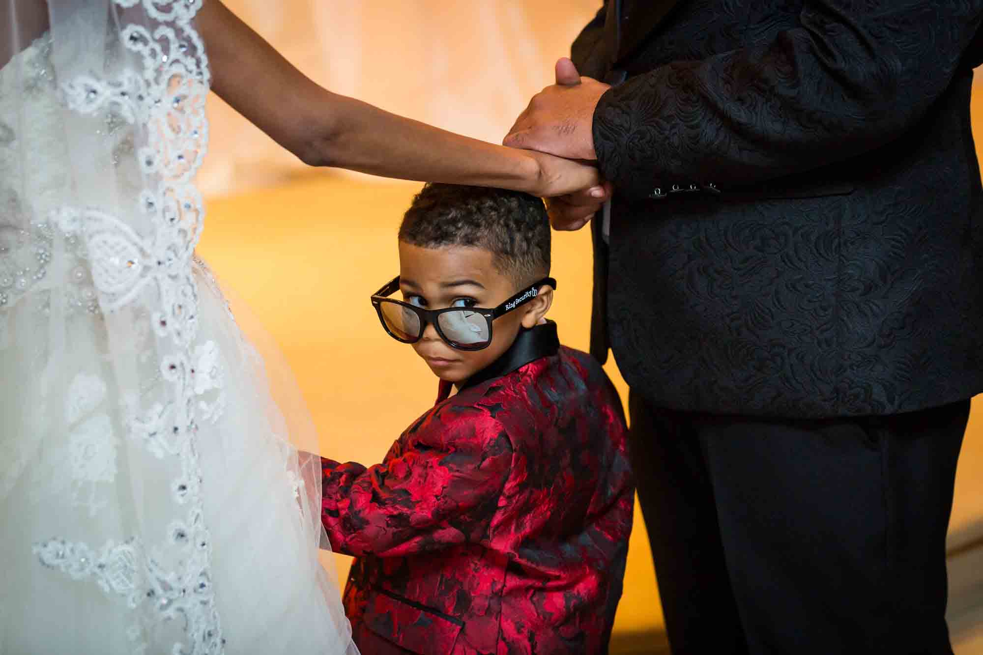 Little boy wearing big sunglasses looking backwards for an article on how to find a San Antonio wedding photographer