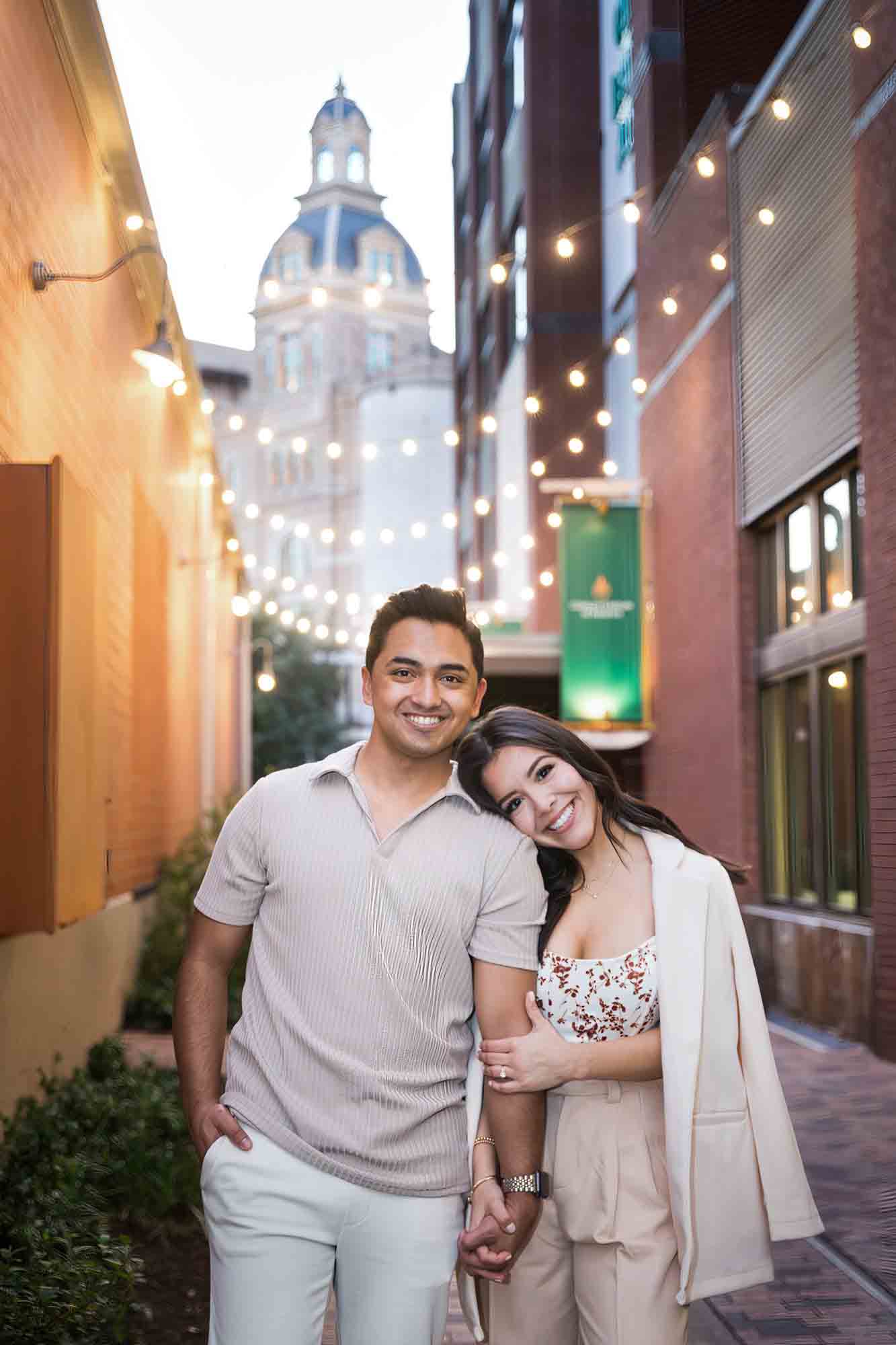 Couple hugging in front of fairy lights at the Pearl by San Antonio photographer, Kelly Williams