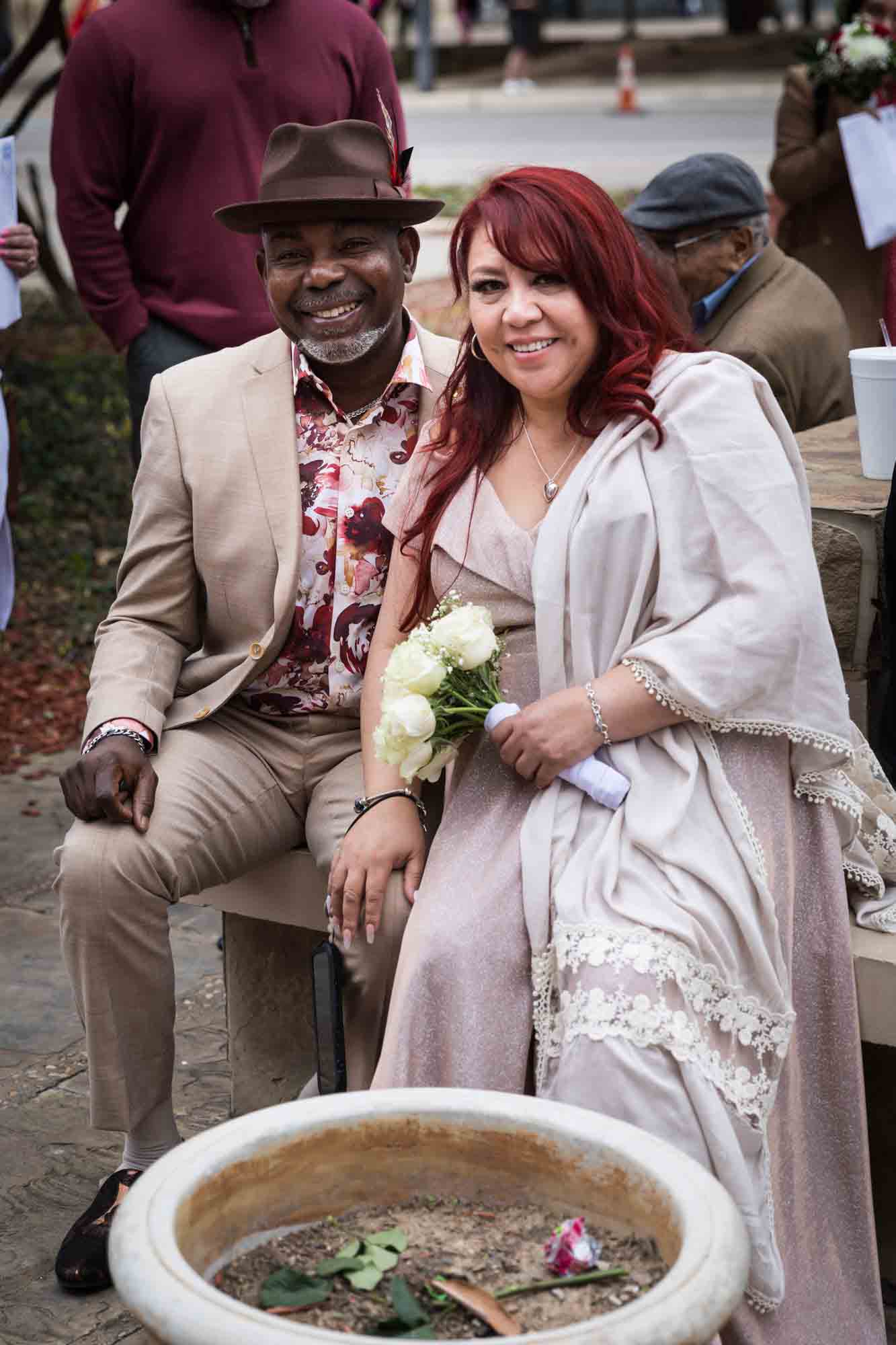 African American man wearing brown hat next to white bride with red hair for an article on the Bexar county mass wedding event