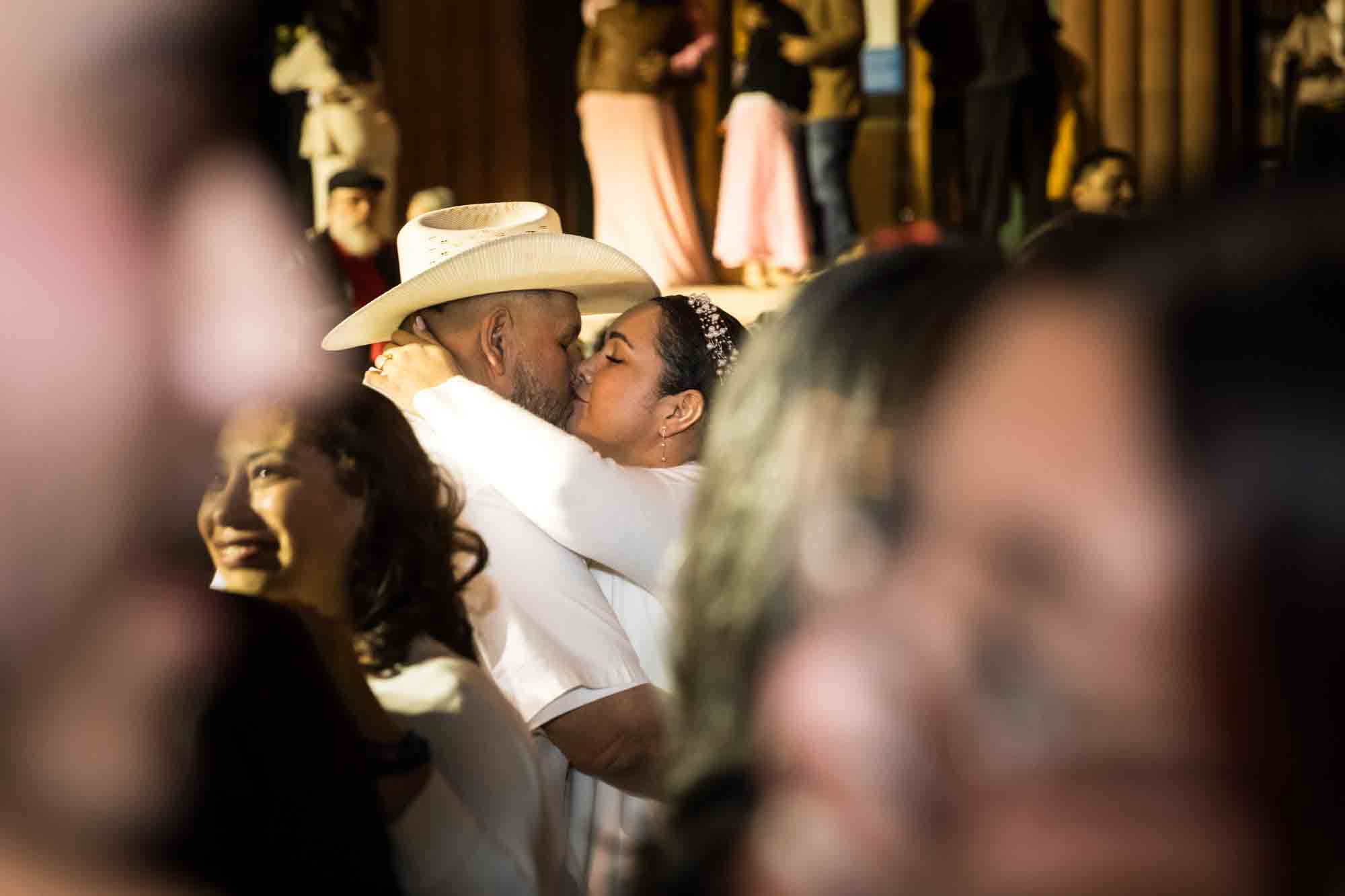 Couple kissing in crowd for an article on the Bexar county mass wedding event