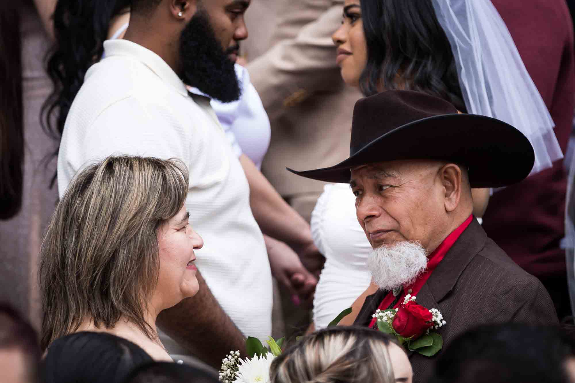 Older woman looking at older man wearing black cowboy hat for an article on the Bexar county mass wedding event