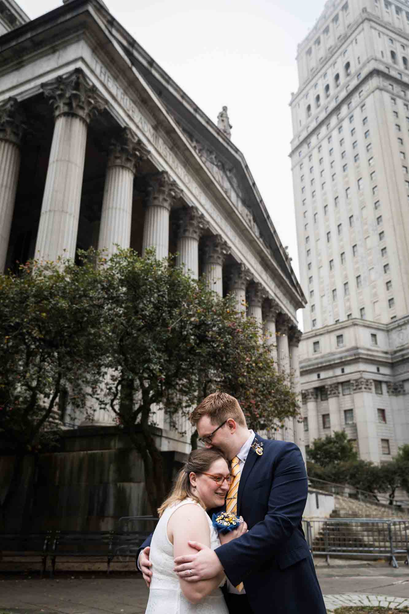 Couple kissing in front of Greek-style federal building for an article on how to get a marriage license in San Antonio