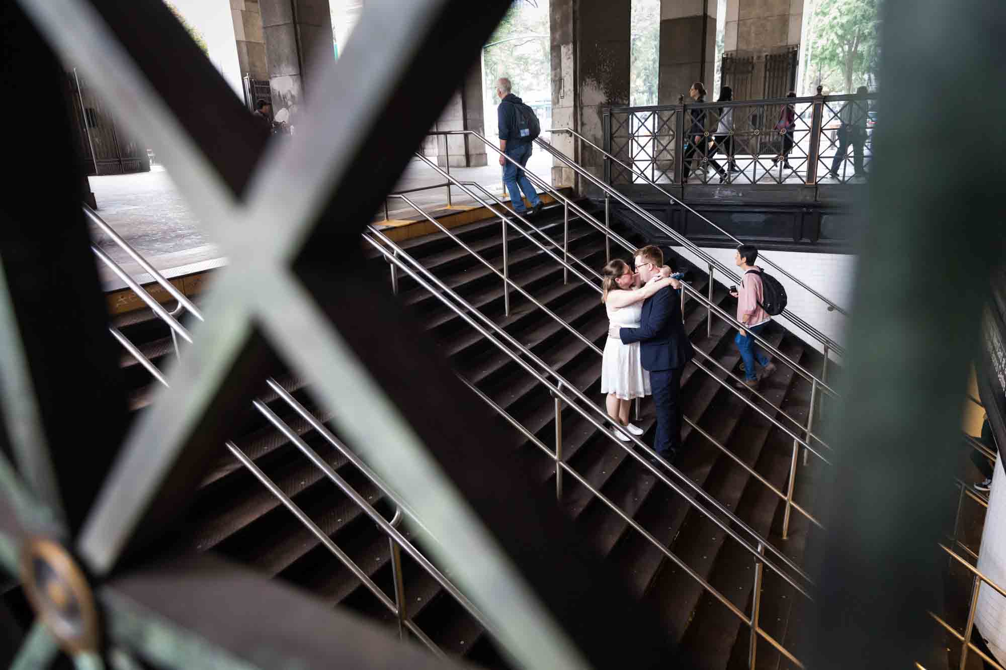 Couple hugging on staircase with view through railing for an article on how to get a marriage license in San Antonio