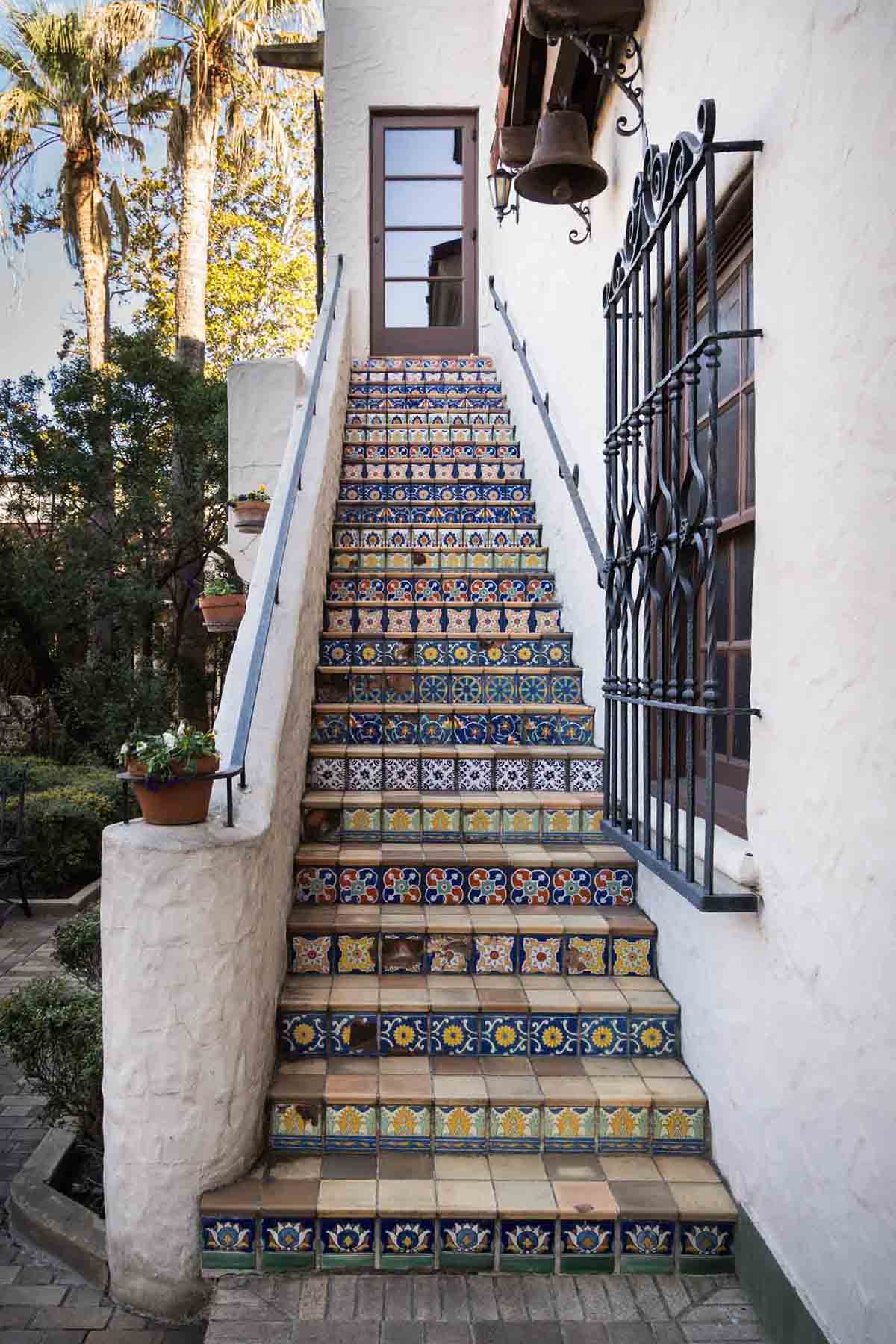 Staircase with colorful tiles and wrought iron window for an article on how to take photos at the McNay Art Museum