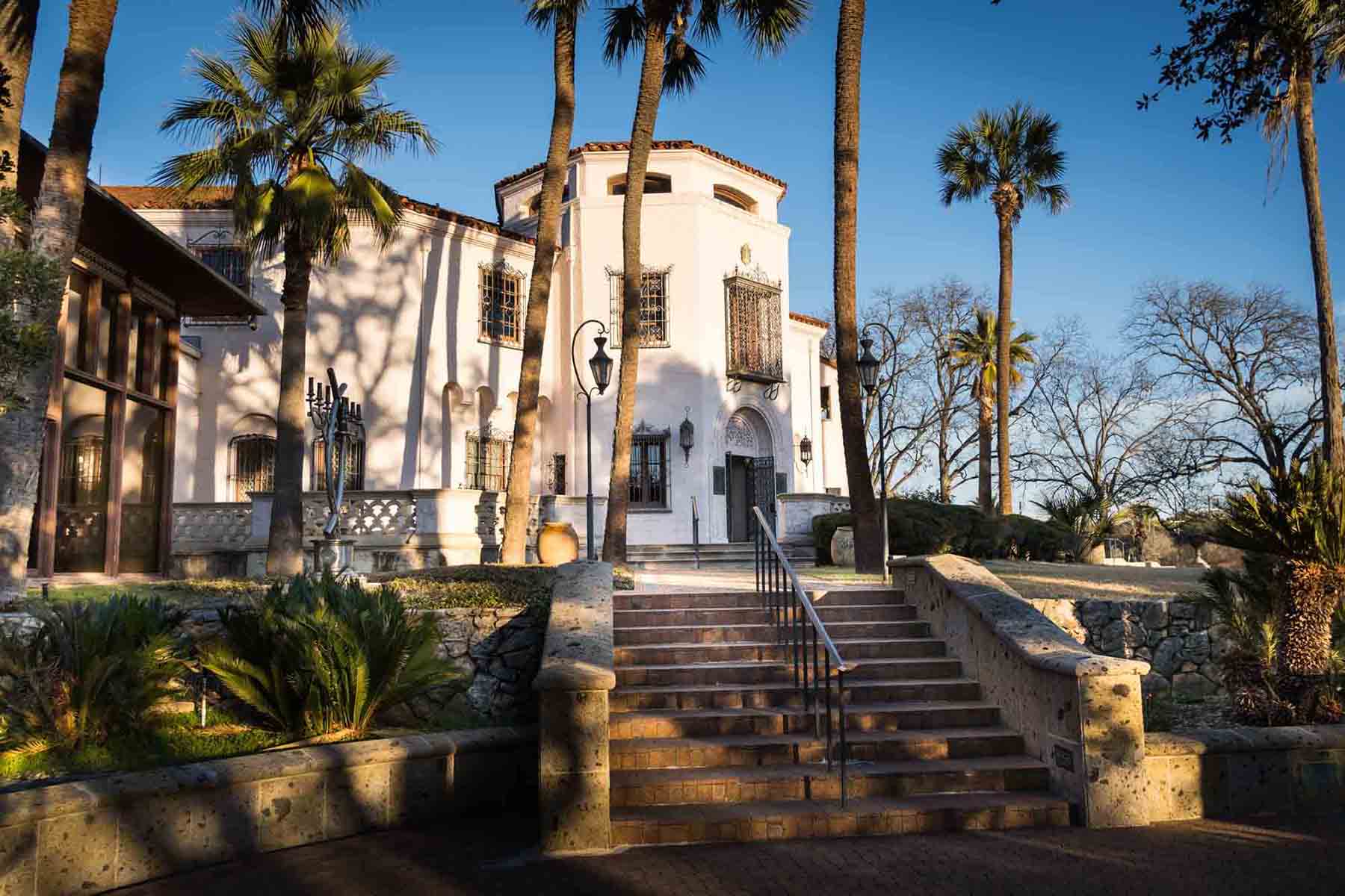 Main house of McNay Art Museum with palm trees and stairs in front for an article on how to take photos at the McNay Art Museum