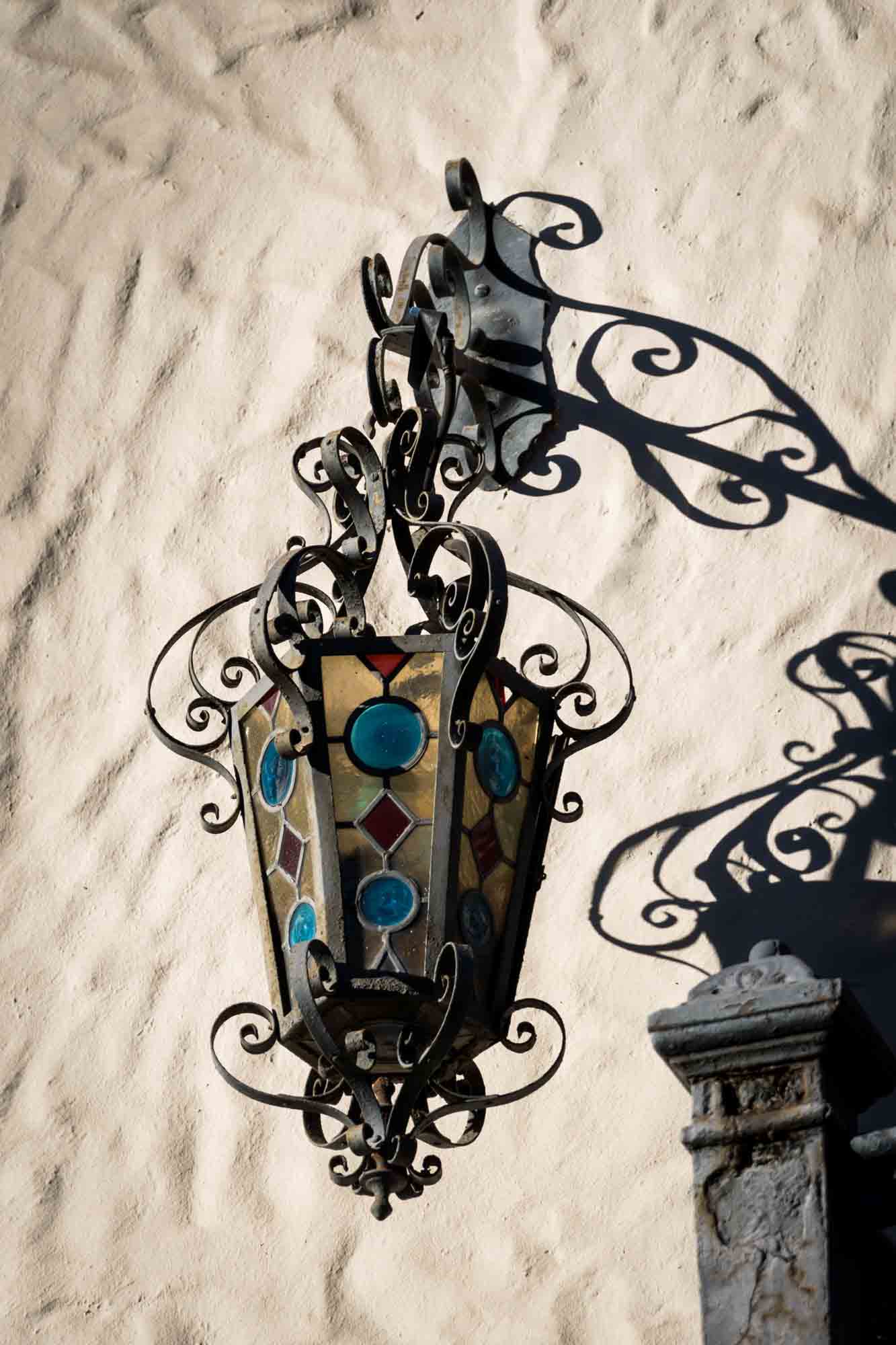 Intricate wrought iron lantern with colorful glass for an article on how to take photos at the McNay Art Museum
