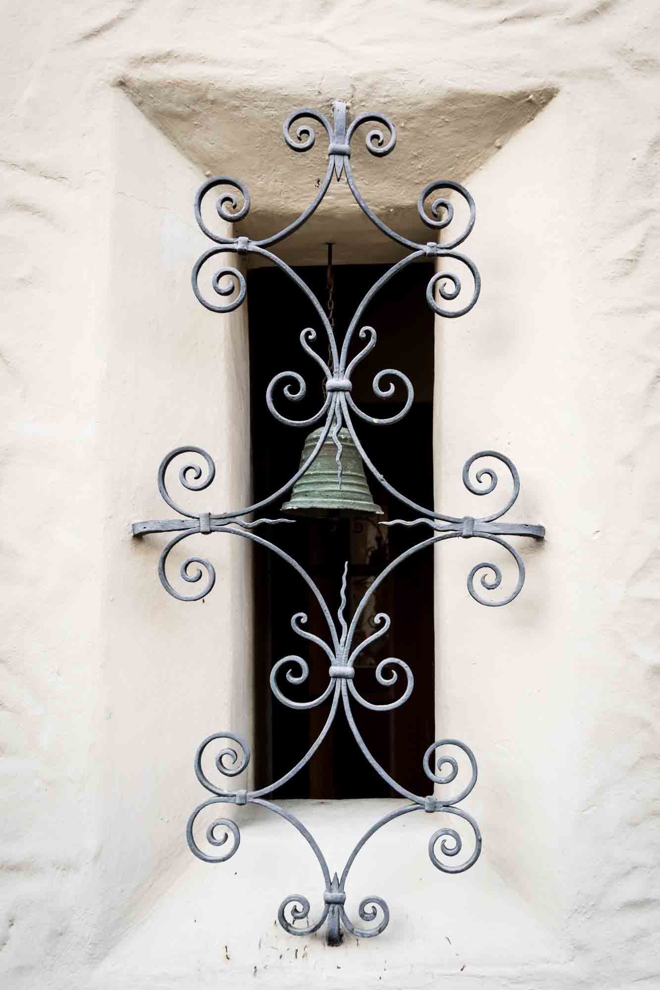 Intricate wrought iron detail with bell for an article on how to take photos at the McNay Art Museum