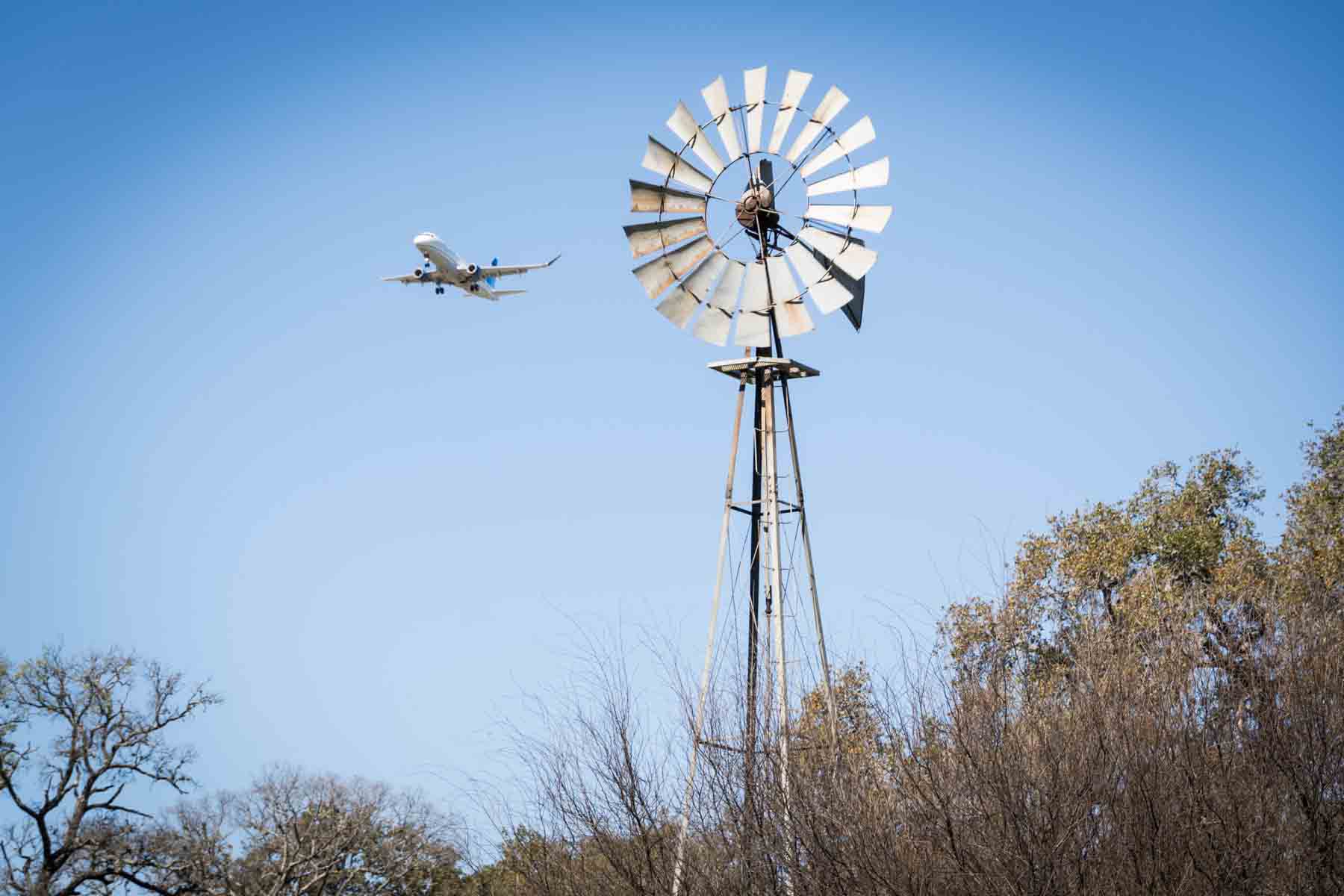 Airplane flying near metal fan in Walker Ranch Park for an article on the best San Antonio parks for family portraits