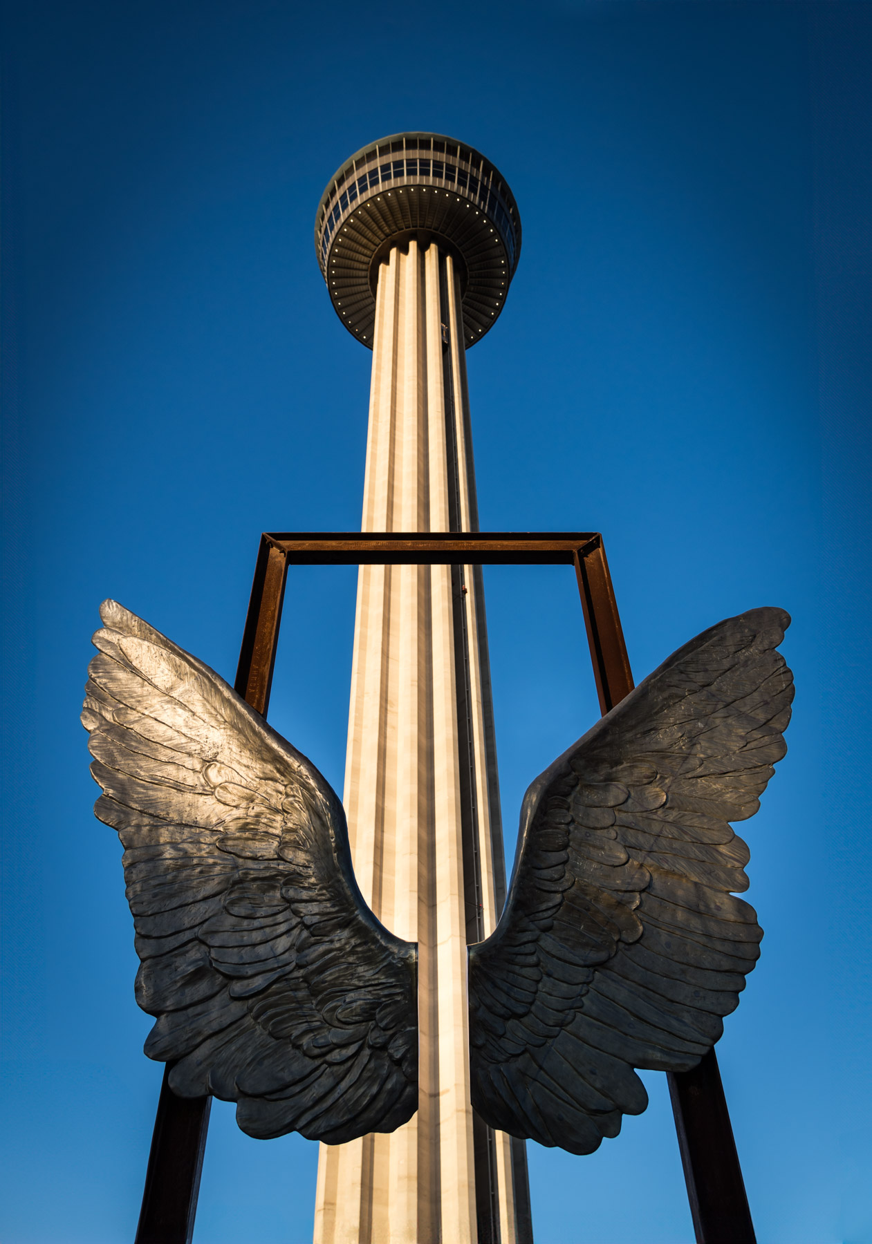 Angel wing sculpture with Tower of the Americas in the background in Hemisfair Park for an article on how to propose at the Tower of the Americas