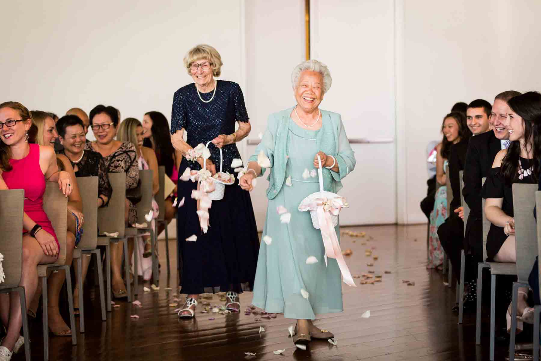 Two grandmothers throwing rose petals during ceremony for an article on the best wedding jobs for family and friends