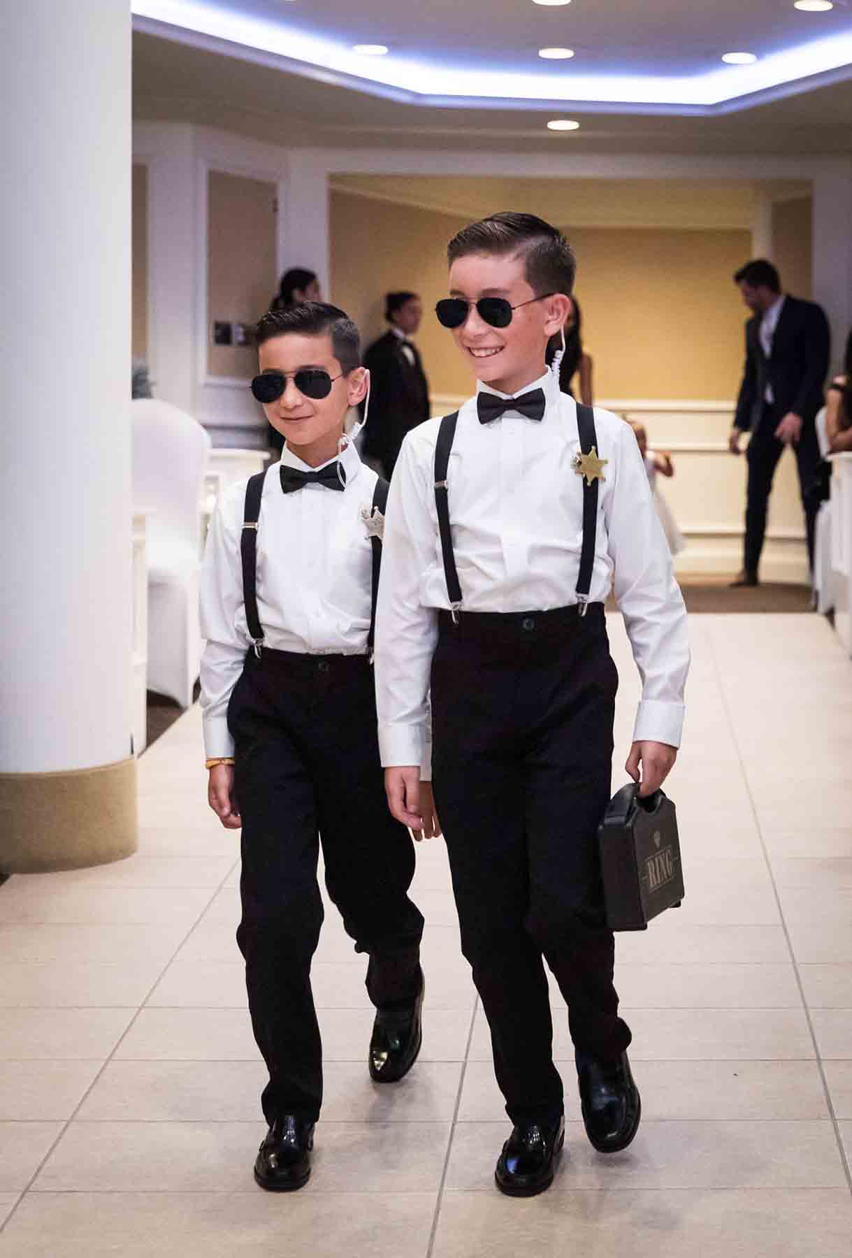 Two little ring bearers dressed as secret service agents for an article on the best wedding jobs for family and friends