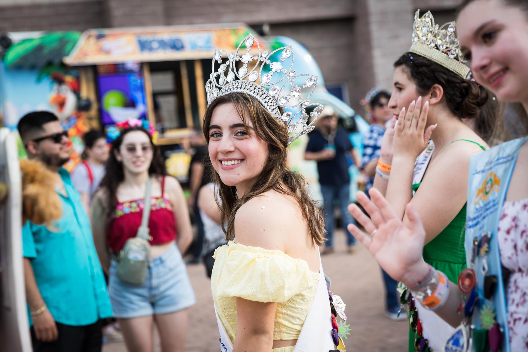 Young princess wearing off-shoulder yellow dress and large tiara for an article on the best Fiesta photos