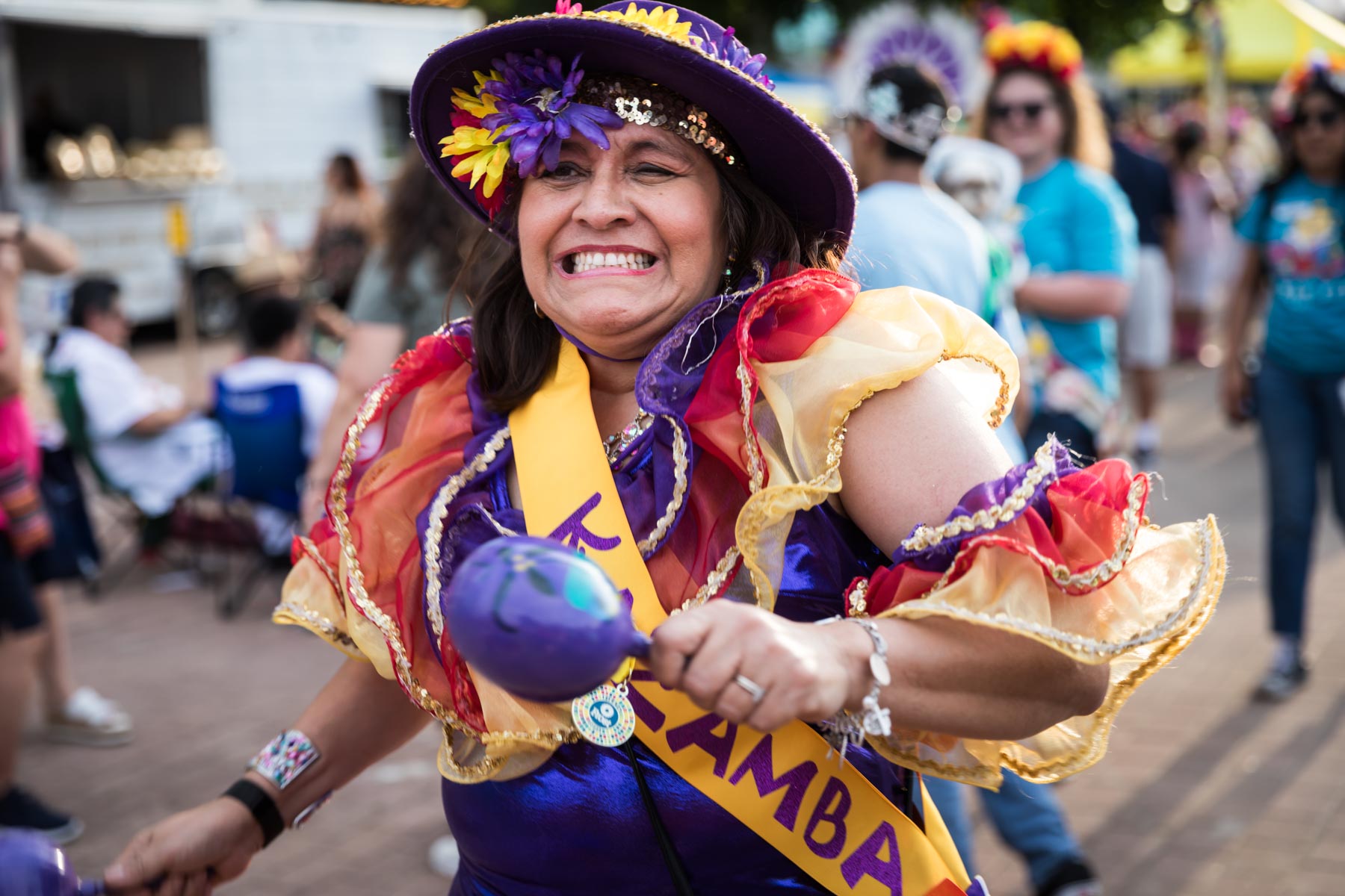 Female dancer wearing hat and shaking maracas during Fiesta Fiesta for an article on the best Fiesta photos