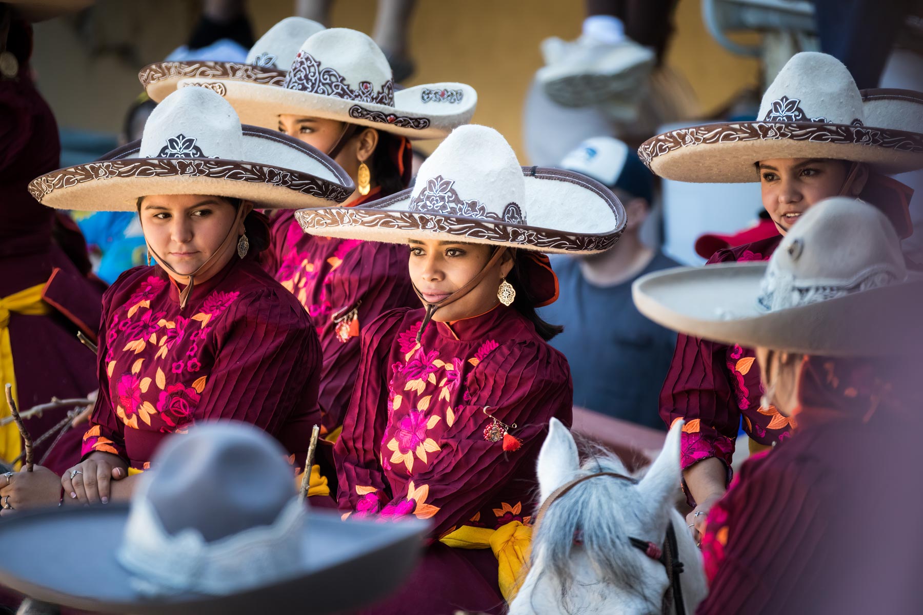 Female horseback riders wearing traditional cowboy hats during Day at Old Mexico for an article on the best Fiesta photos