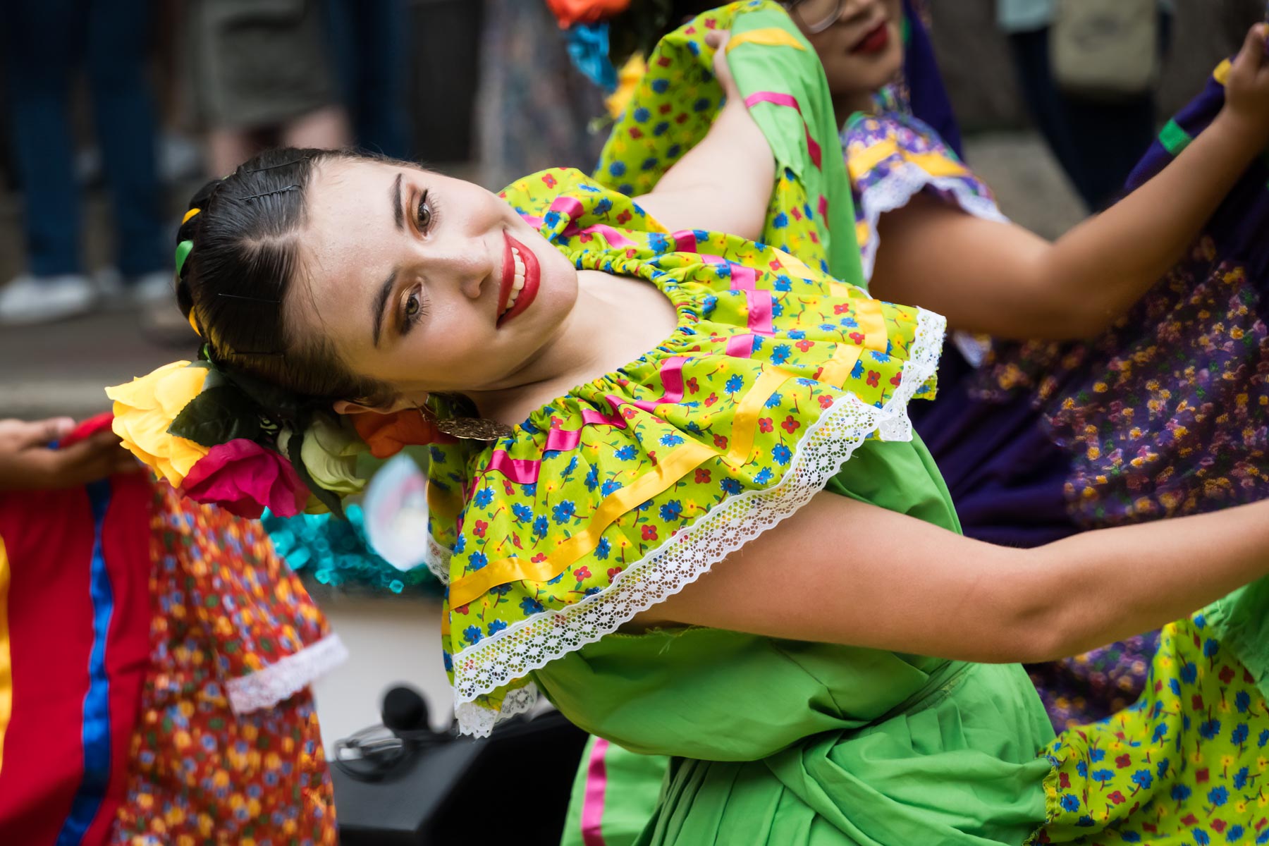Dancer turned to the side wearing green and yellow dress for an article on the best Fiesta photos