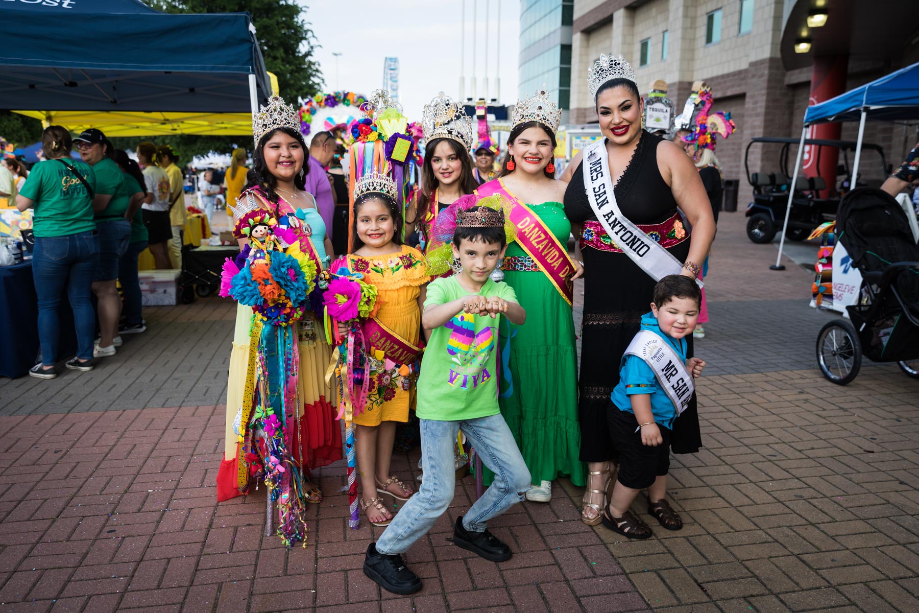 Royal court posed together wearing colorful outfits and tiaras for an article on the best Fiesta photos