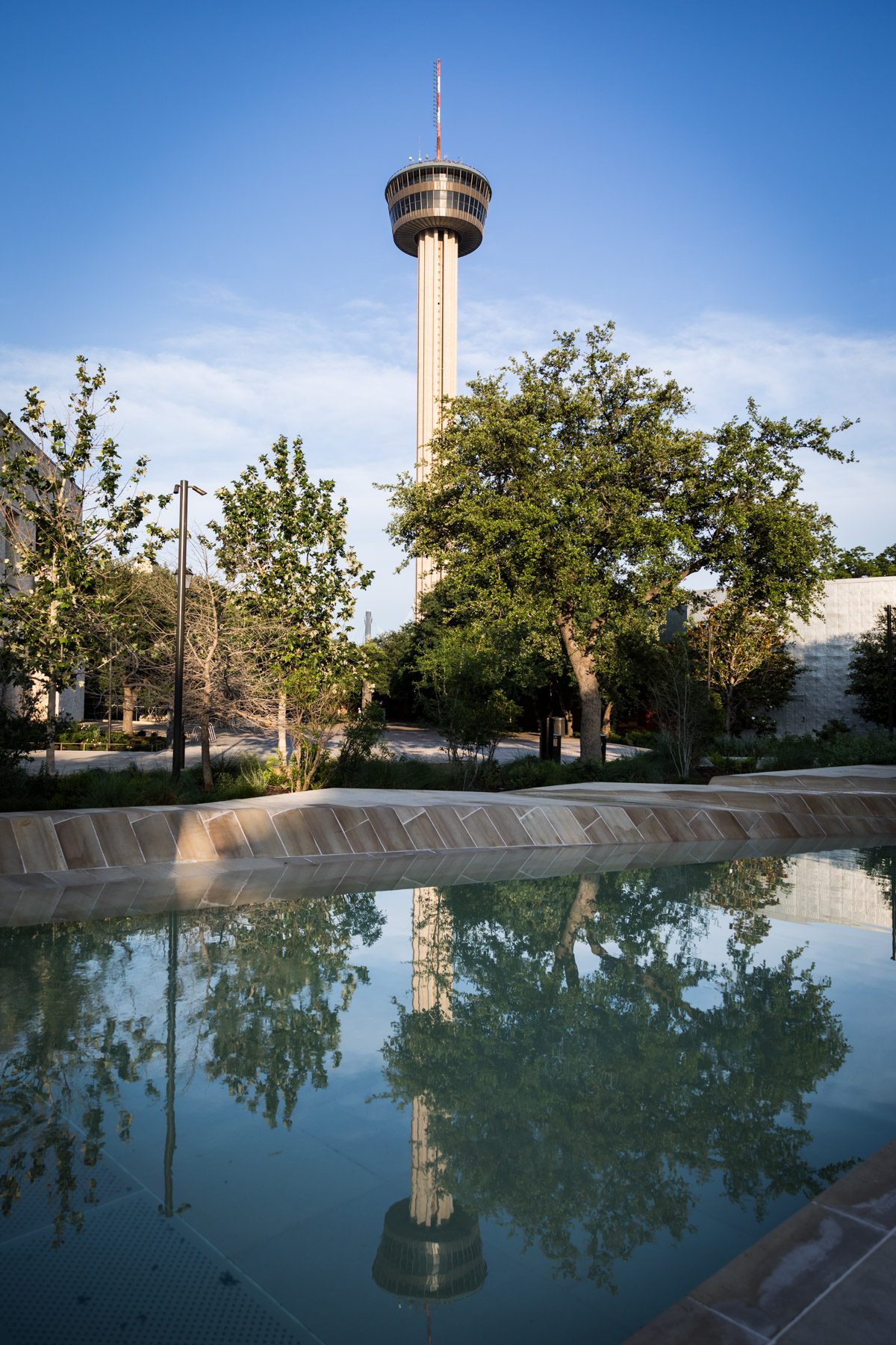 River fountain with Tower of the Americas in the background for an article on the perfect downtown San Antonio family portrait itinerary