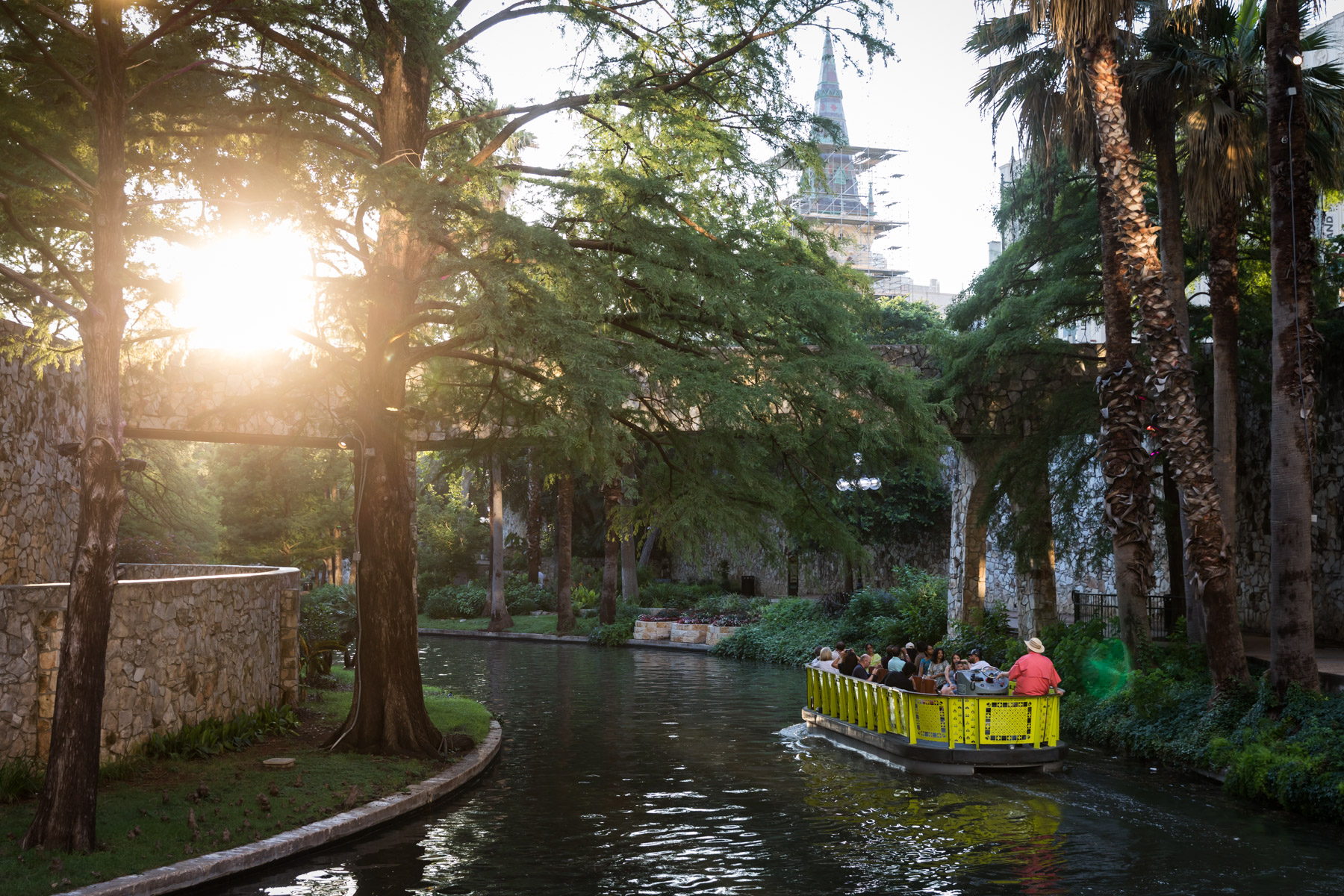 Boat carrying tourists on San Antonio River Walk for an article on the perfect downtown San Antonio family portrait itinerary
