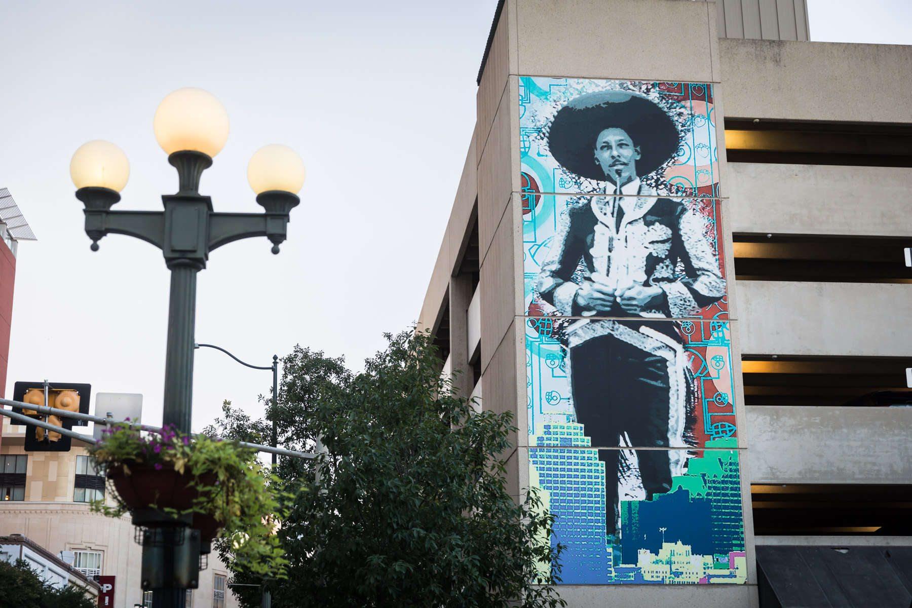 Public mural of mariachi wearing traditional clothing with lamp post in foreground for an article on the perfect downtown San Antonio family portrait itinerary