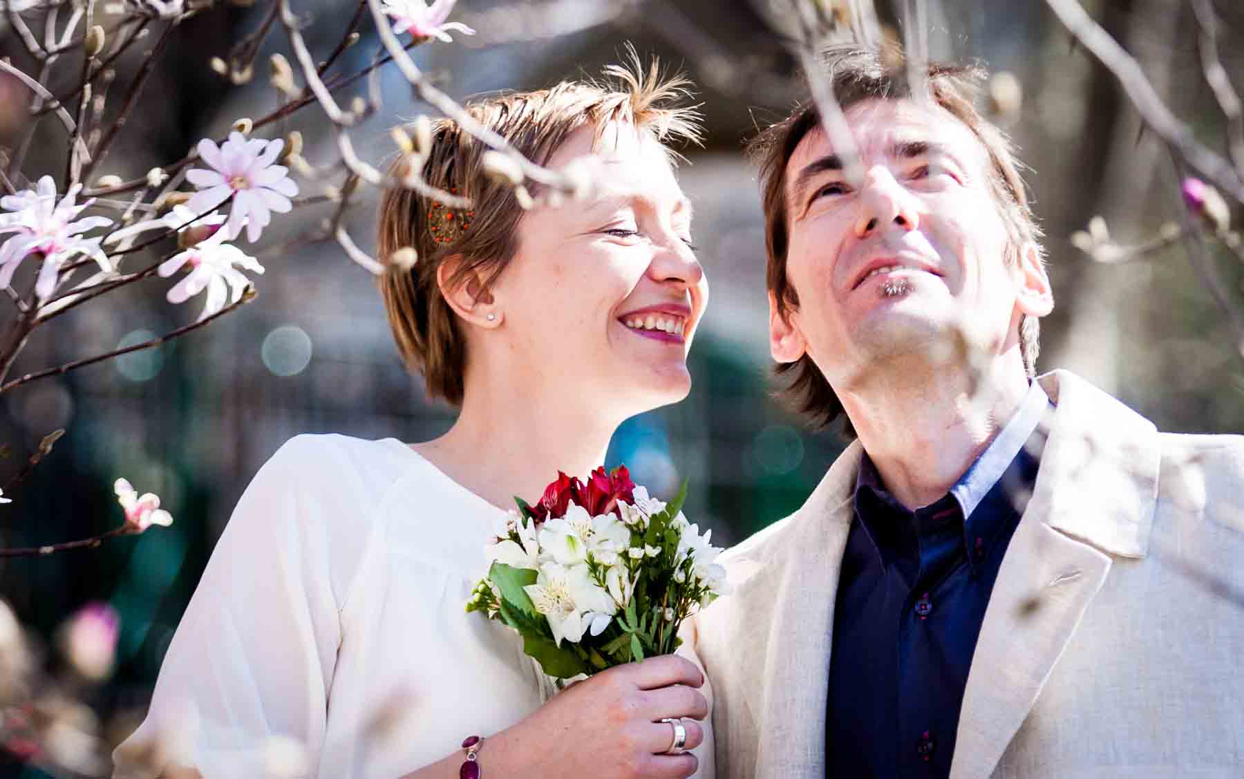 Woman smiling at man with brown hair and holding flowers for an article entitled, ‘Are Couples Still Getting Married?’