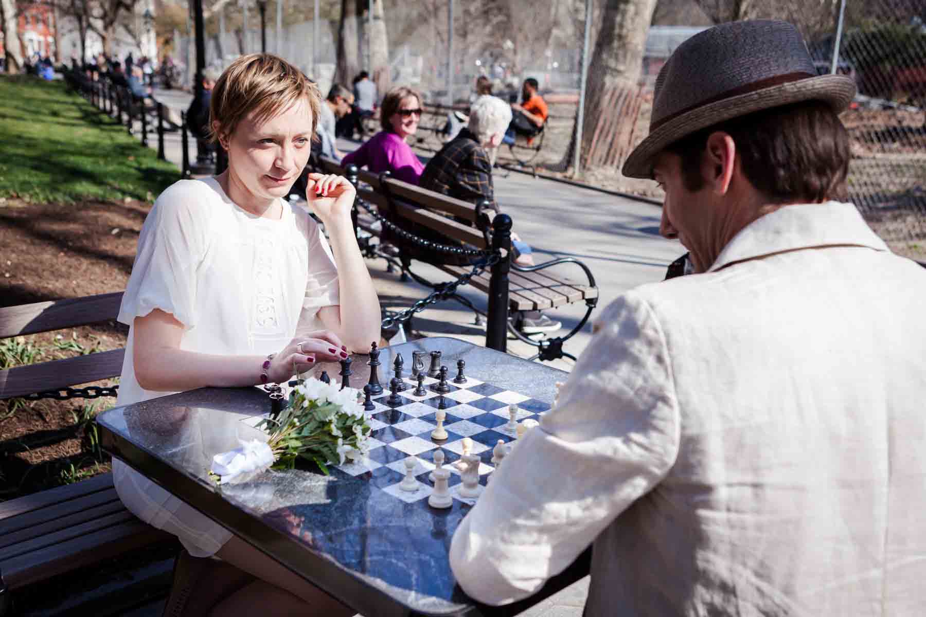 Man and woman playing chess in park for an article entitled, ‘Are Couples Still Getting Married?’