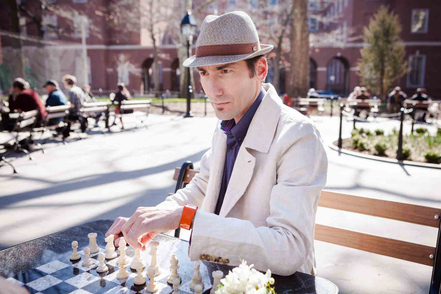 Man wearing hat and white jacket about to move chess piece for an article entitled, ‘Are Couples Still Getting Married?’