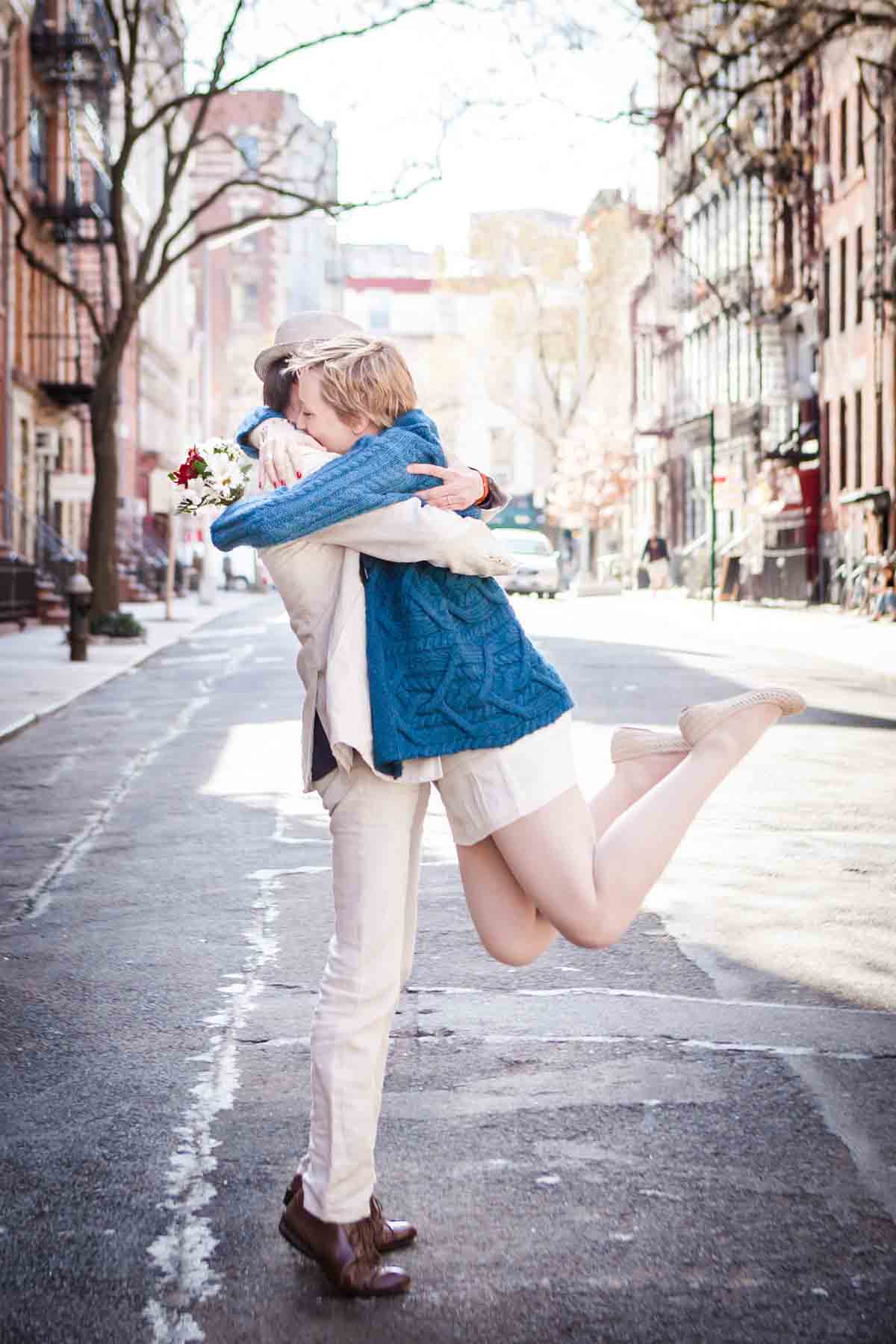 Man lifting woman up with a hug in middle of street for an article entitled, ‘Are Couples Still Getting Married?’