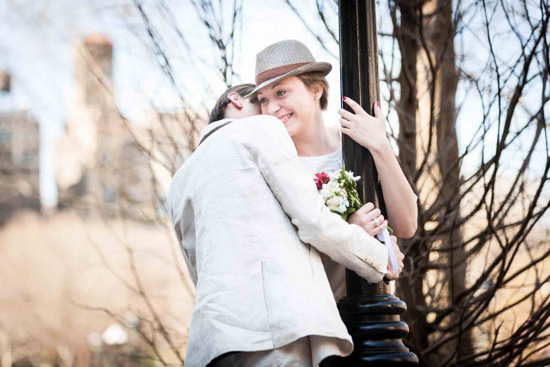 Man kissing woman wearing hat on the side of head for an article entitled, ‘Are Couples Still Getting Married?’