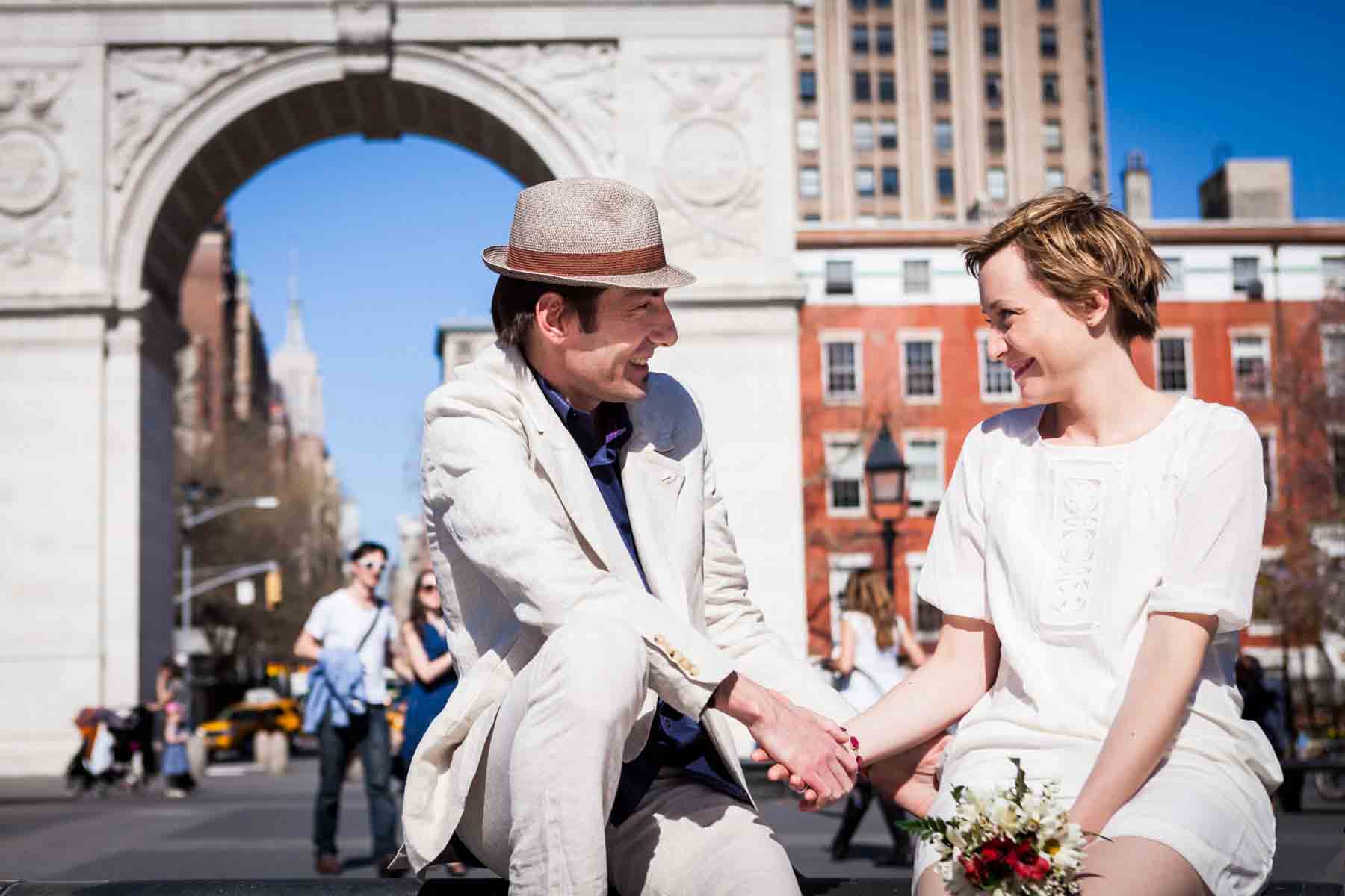 Couple looking at each other in front of Washington Square Arch for an article entitled, ‘Are Couples Still Getting Married?’