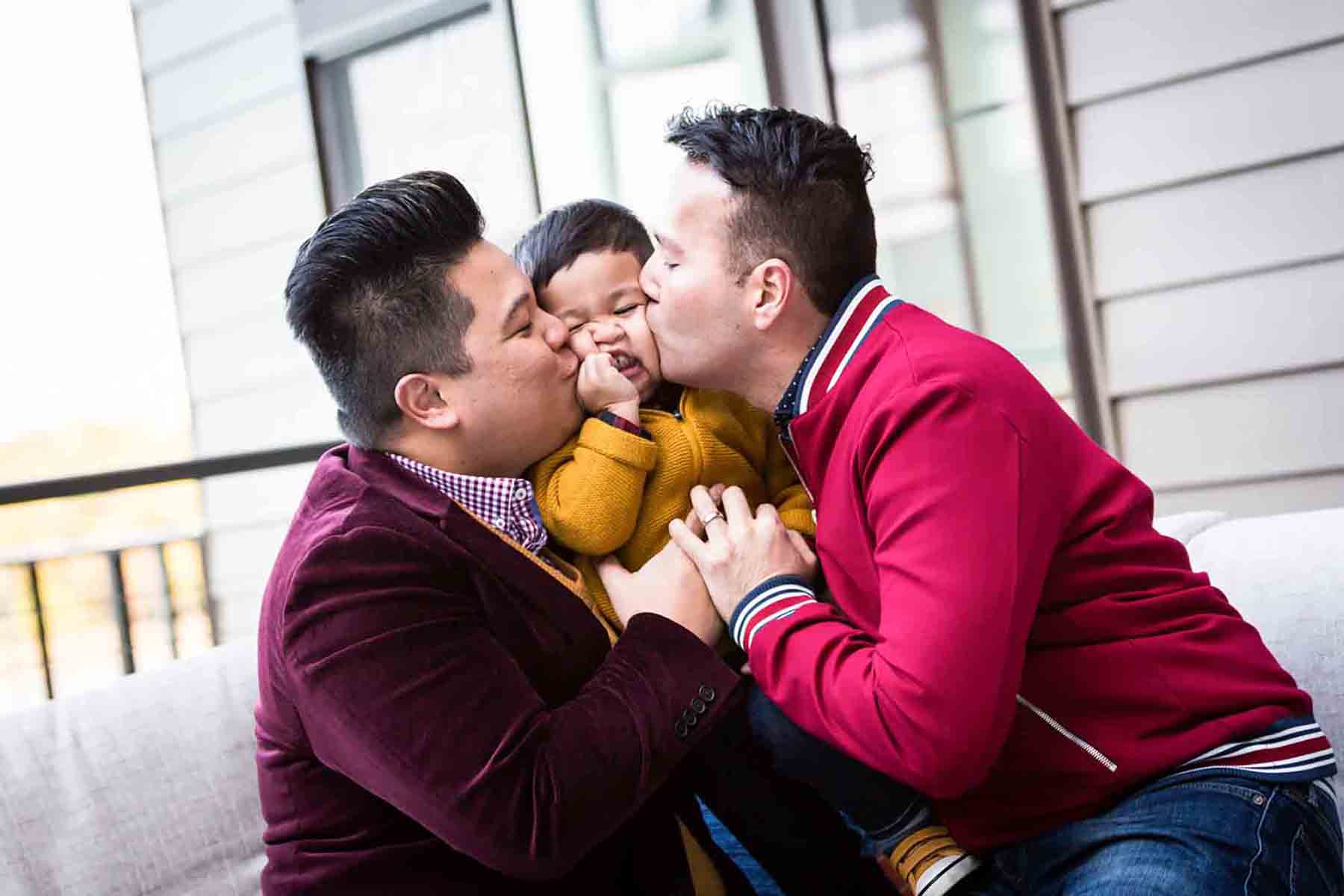 Two gay fathers kissing little boy on both cheeks for an article on daddy and me photo shoot ideas