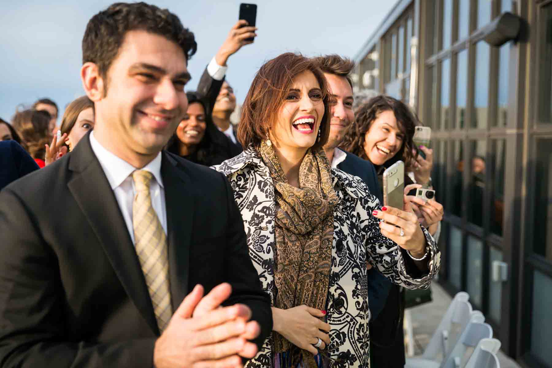 Guests cheering during outdoor ceremony for an article on how to save money on wedding photography