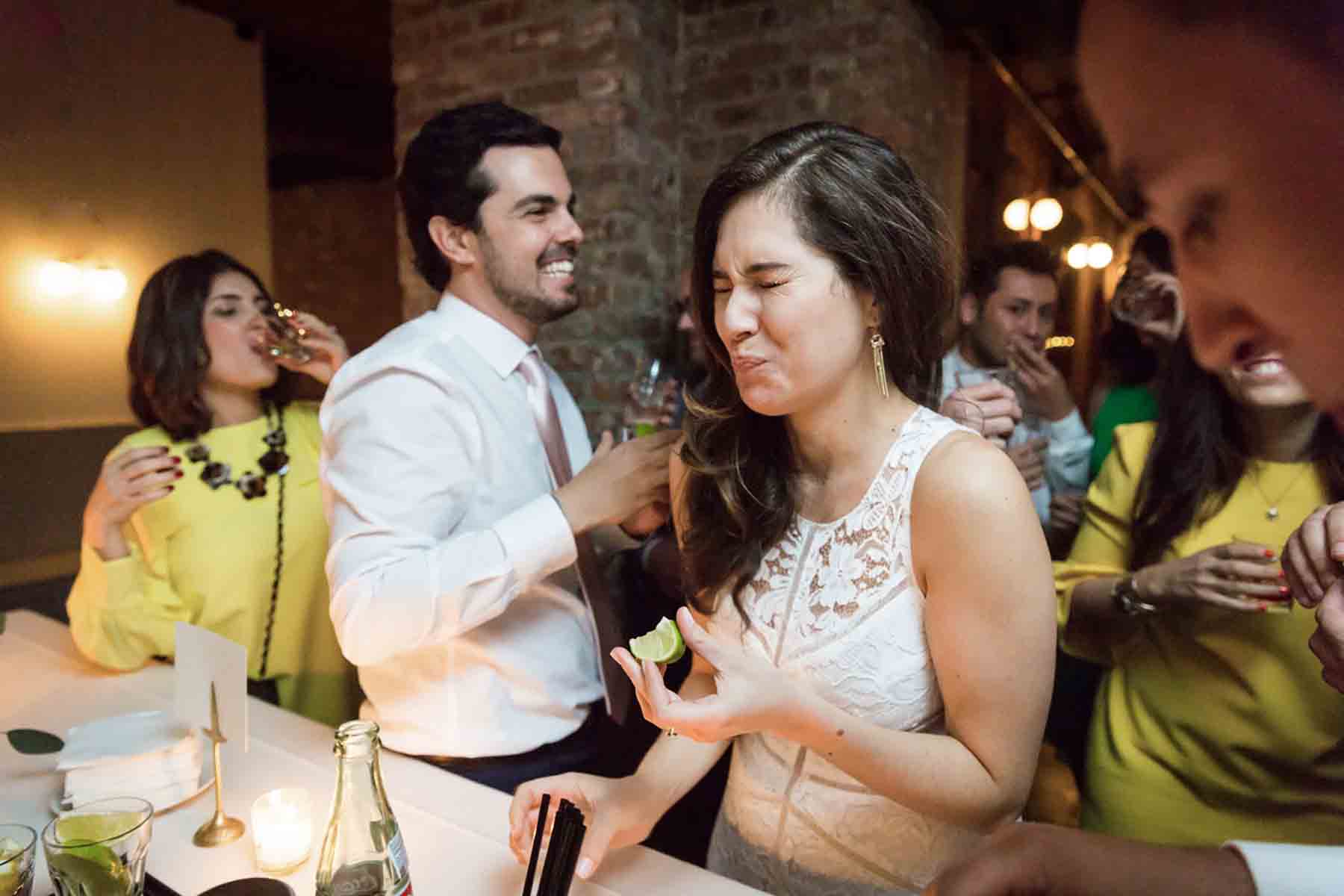 Bride and groom eating lime and drinking tequila for an article on how to save money on wedding photography