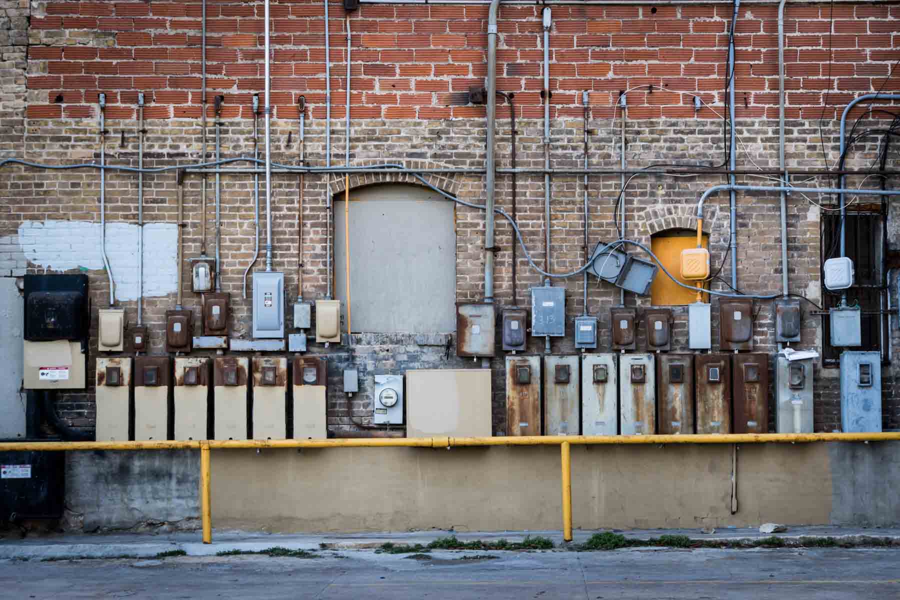 Brick wall covered over in electrical boxes for an article on secret San Antonio photo shoot locations