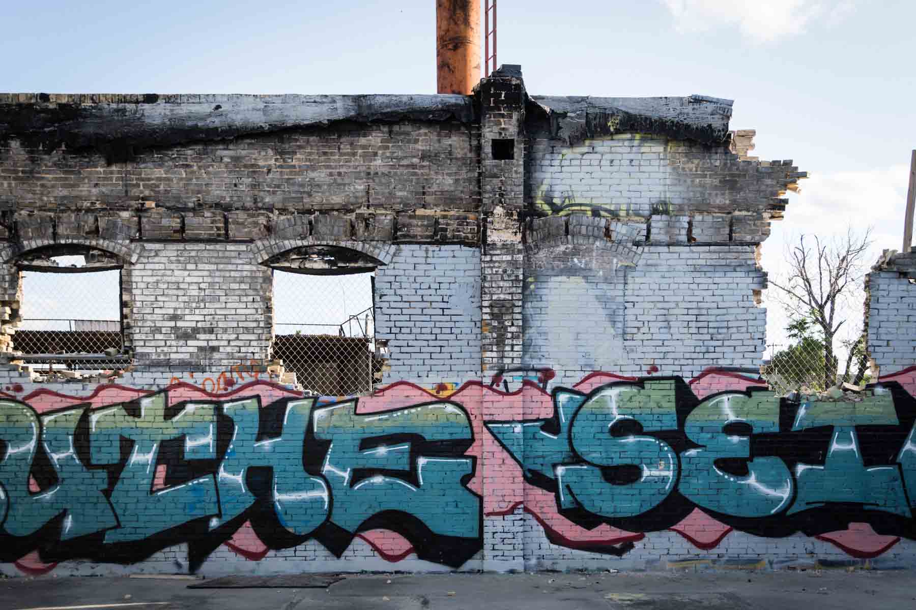 Broken, white brick wall with colorful graffiti for an article on secret San Antonio photo shoot locations