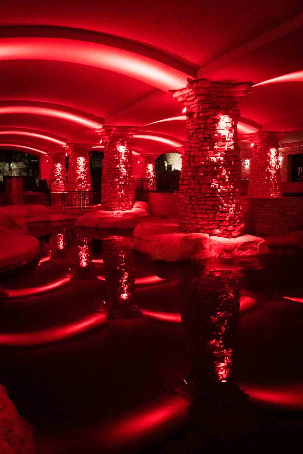 Space underground lit by red lights against brick columns for an article on secret San Antonio photo shoot locations