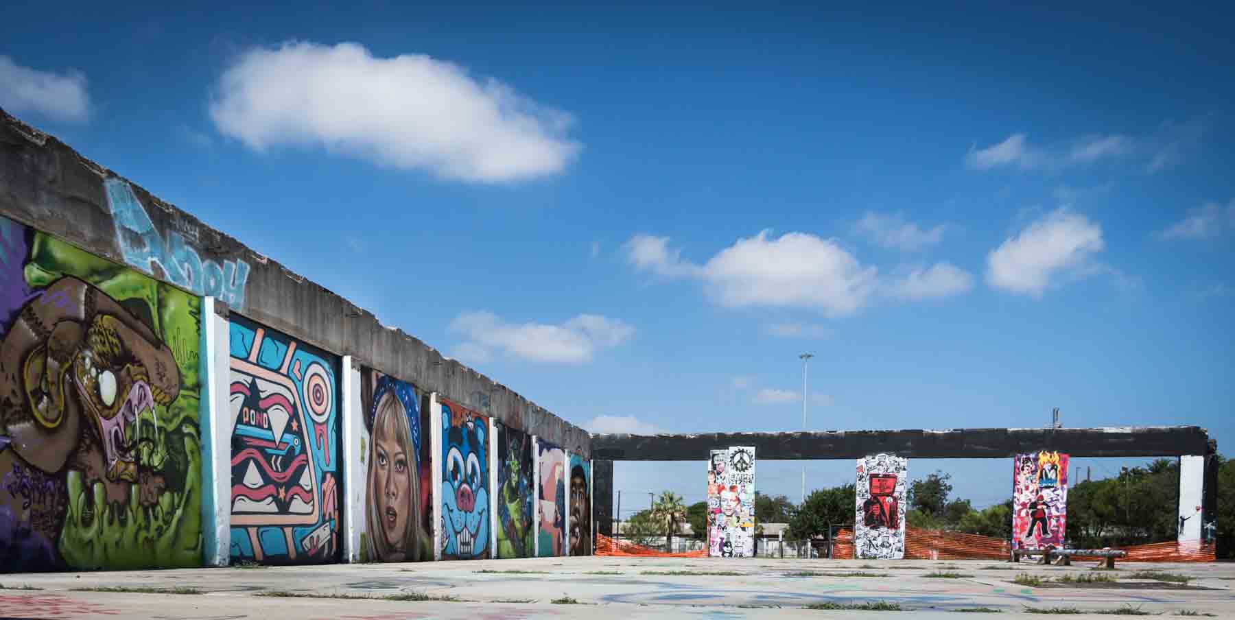 Colorful graffiti murals against building with blue sky overhead for an article on secret San Antonio photo shoot locations