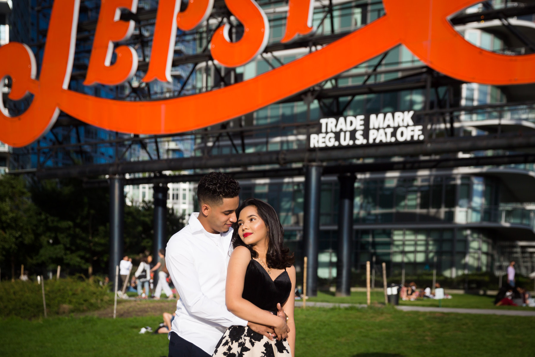 Couple hugging in front of Pepsi Cola neon sign for an article on how to beat the summer heat during a photo shoot