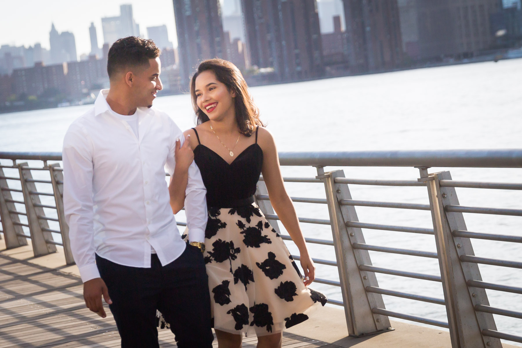 Couple walking on boardwalk with city skyline in background for an article on how to beat the summer heat during a photo shoot